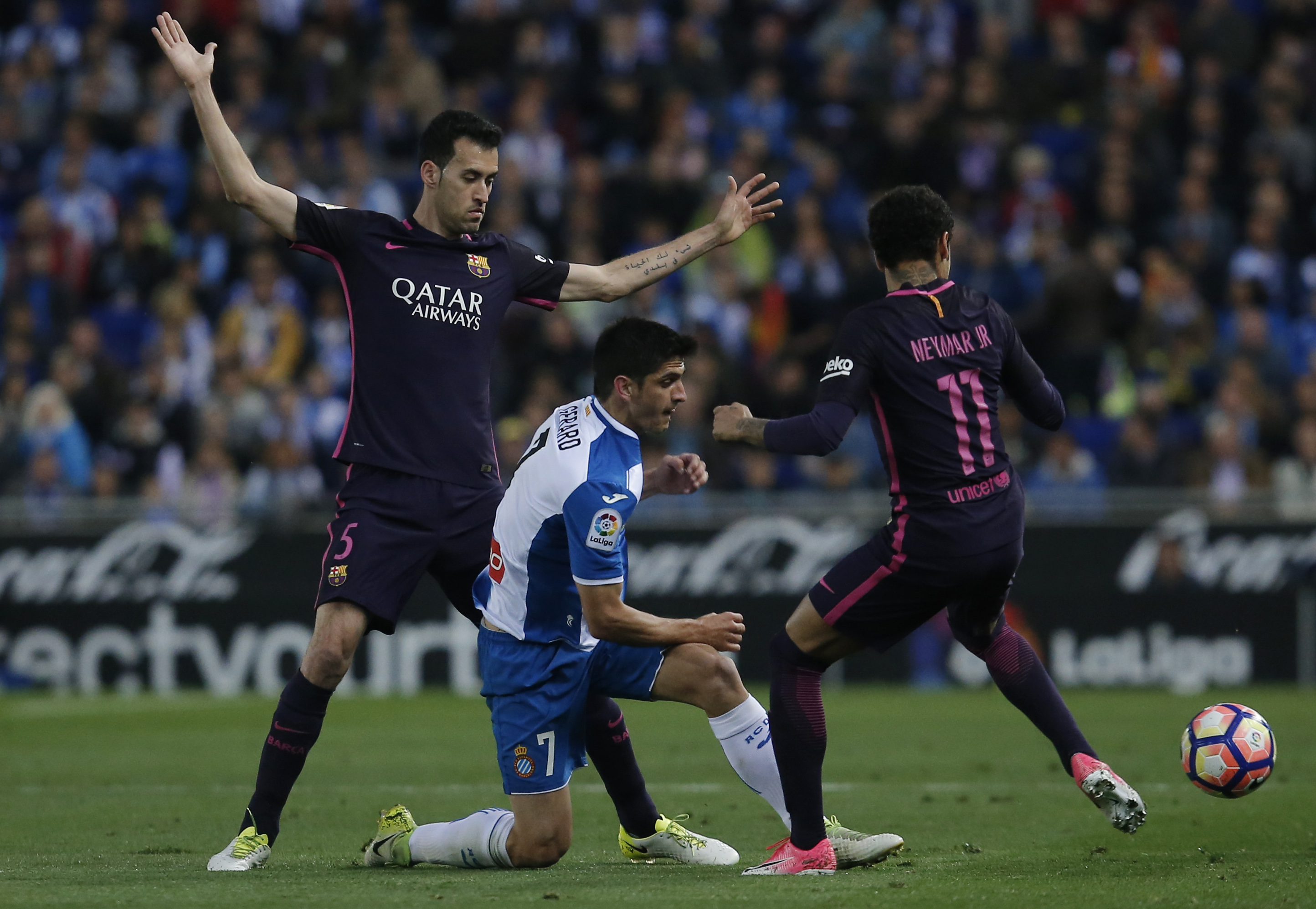 Espanol's forward Gerard Moreno (C) vies with Barcelona's midfielder Sergio Busquets (L) and Barcelona's Brazilian forward Neymar during the Spanish league football match RCD Espanyol vs FC Barcelona at the Cornella-El Prat stadium in Cornella de Llobregat on April 29, 2017. / AFP PHOTO / PAU BARRENA (Photo credit should read PAU BARRENA/AFP/Getty Images)