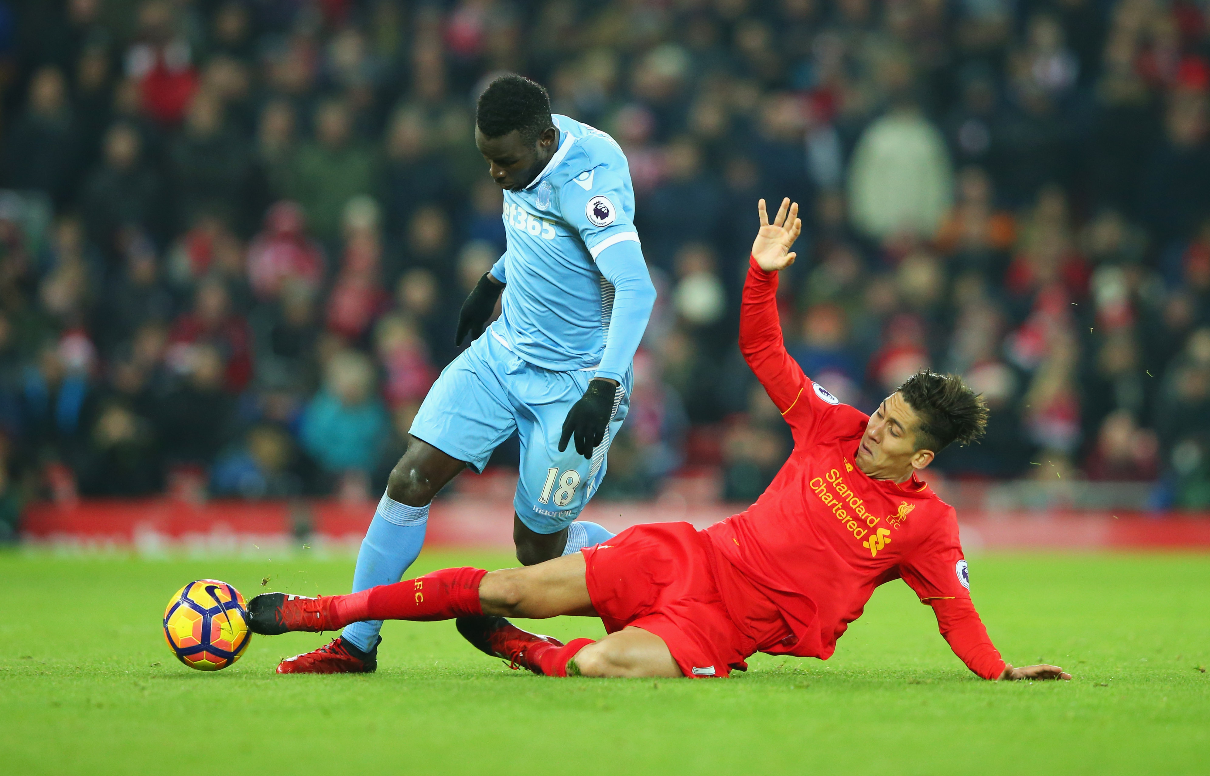 LIVERPOOL, ENGLAND - DECEMBER 27: Mame Biram Diouf of Stoke City is challenged by Roberto Firmino of Liverpool during the Premier League match between Liverpool and Stoke City at Anfield on December 27, 2016 in Liverpool, England. (Photo by Alex Livesey/Getty Images)