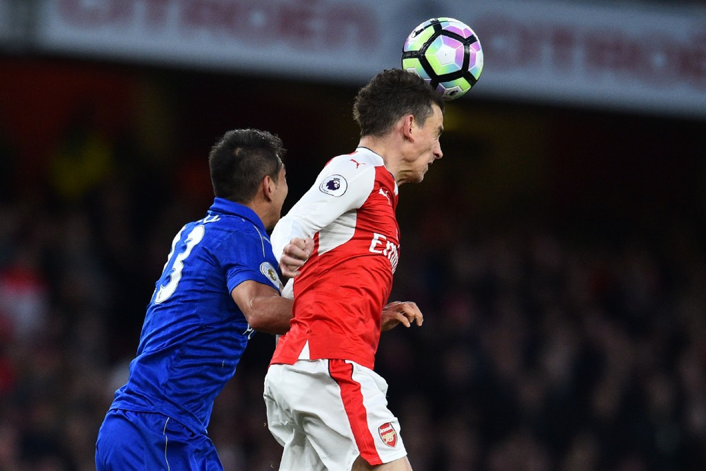Arsenal's French defender Laurent Koscielny (R) heads the ball under pressure from Leicester City's Argentinian striker Leonardo Ulloa during the English Premier League football match between Arsenal and Leicester City at the Emirates Stadium in London on April 26, 2017. / AFP PHOTO / Glyn KIRK / RESTRICTED TO EDITORIAL USE. No use with unauthorized audio, video, data, fixture lists, club/league logos or 'live' services. Online in-match use limited to 75 images, no video emulation. No use in betting, games or single club/league/player publications. / (Photo credit should read GLYN KIRK/AFP/Getty Images)