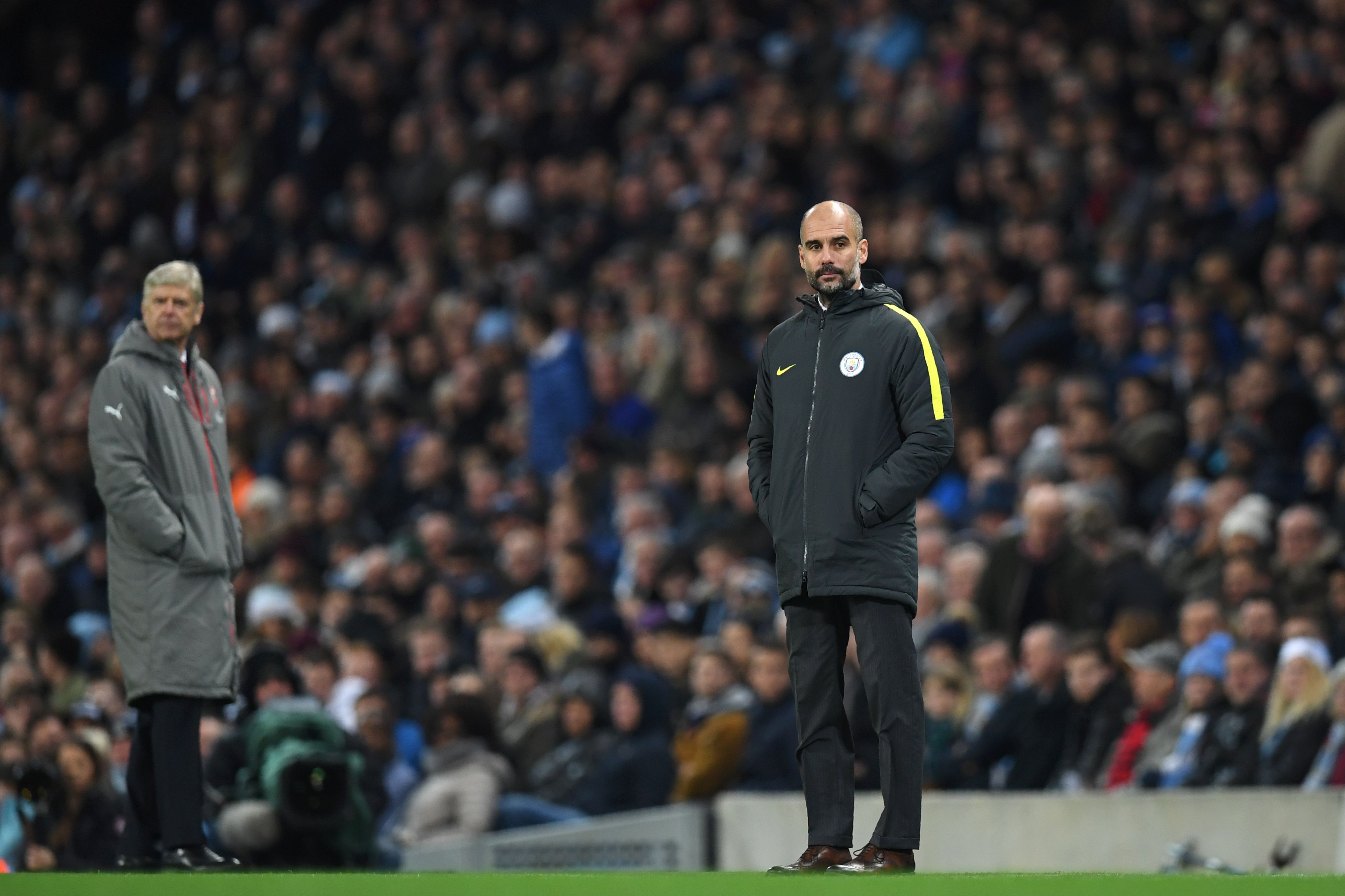 Arsenal's French manager Arsene Wenger (L) and Manchester City's Spanish manager Pep Guardiola watch the game from the touchline during the English Premier League football match between Manchester City and Arsenal at the Etihad Stadium in Manchester, north west England, on December 18, 2016. / AFP / Paul ELLIS / RESTRICTED TO EDITORIAL USE. No use with unauthorized audio, video, data, fixture lists, club/league logos or 'live' services. Online in-match use limited to 75 images, no video emulation. No use in betting, games or single club/league/player publications. / (Photo credit should read PAUL ELLIS/AFP/Getty Images)