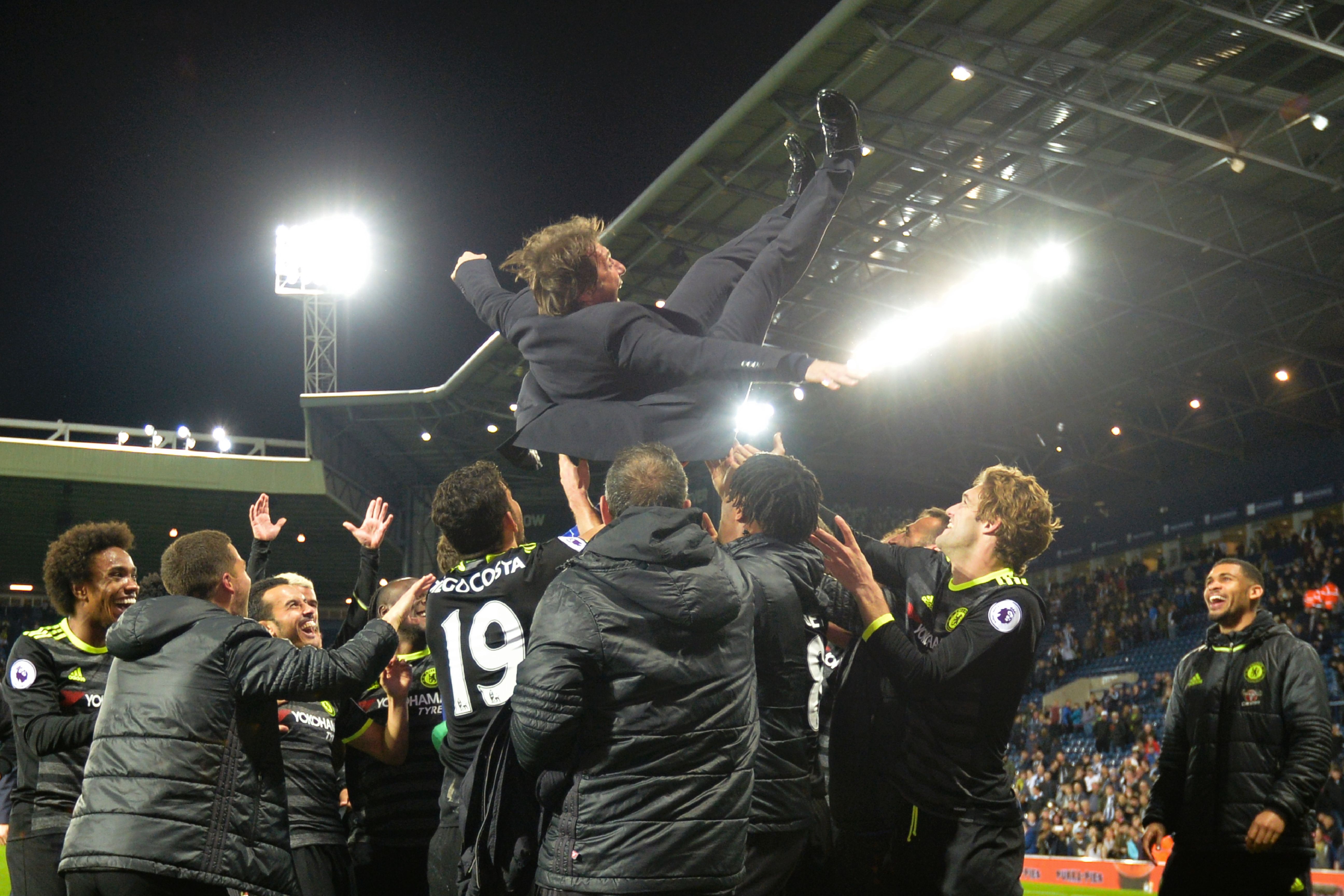 Chelsea's Italian head coach Antonio Conte (top) is thrown in the air by his players as they celebrate being confirmed Premier League champions after the English Premier League match between West Bromwich Albion and Chelsea at The Hawthorns stadium in West Bromwich, west Midlands on May 12, 2017. / AFP PHOTO / Anthony Devlin        (Photo credit should read ANTHONY DEVLIN/AFP/Getty Images)