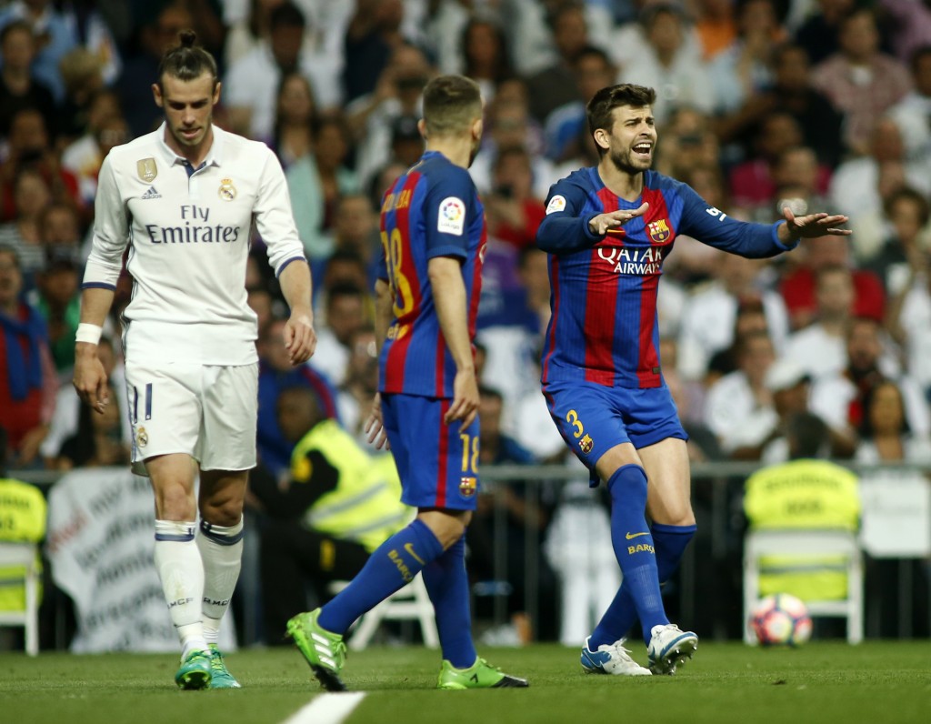 Barcelona's defender Gerard Pique (R) gestures beside Real Madrid's Welsh forward Gareth Bale (L) during the Spanish league football match Real Madrid CF vs FC Barcelona at the Santiago Bernabeu stadium in Madrid on April 23, 2017. / AFP PHOTO / OSCAR DEL POZO (Photo credit should read OSCAR DEL POZO/AFP/Getty Images)