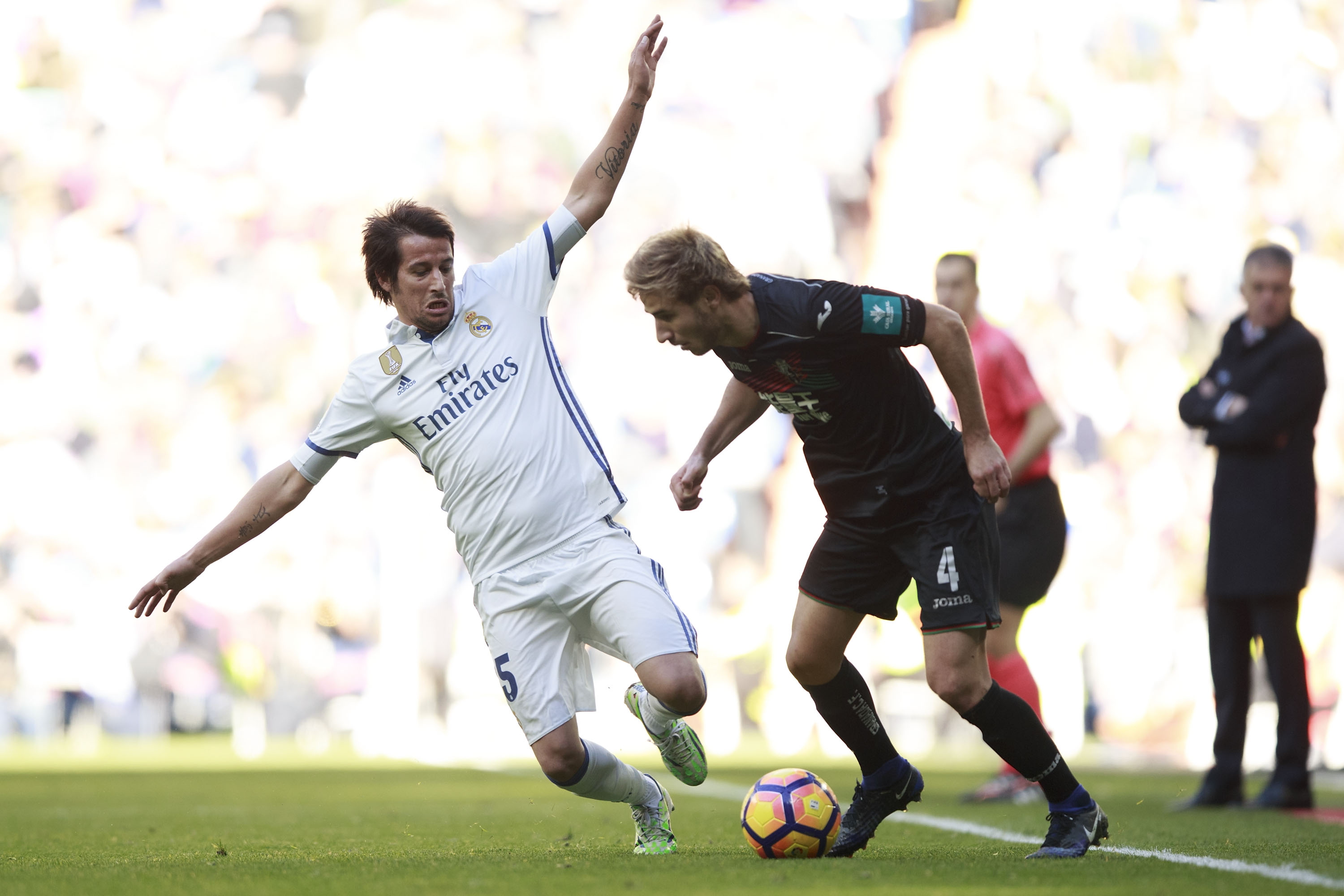 MADRID, SPAIN - JANUARY 07: Raphael Varane (L) of Real Madrid CF competes for the ball with Sergi Samper (R) of Granada CF during the La Liga match between Real Madrid CF and Granada CF at Estadio Santiago Bernabeu on January 7, 2017 in Madrid, Spain. (Photo by Gonzalo Arroyo Moreno/Getty Images)