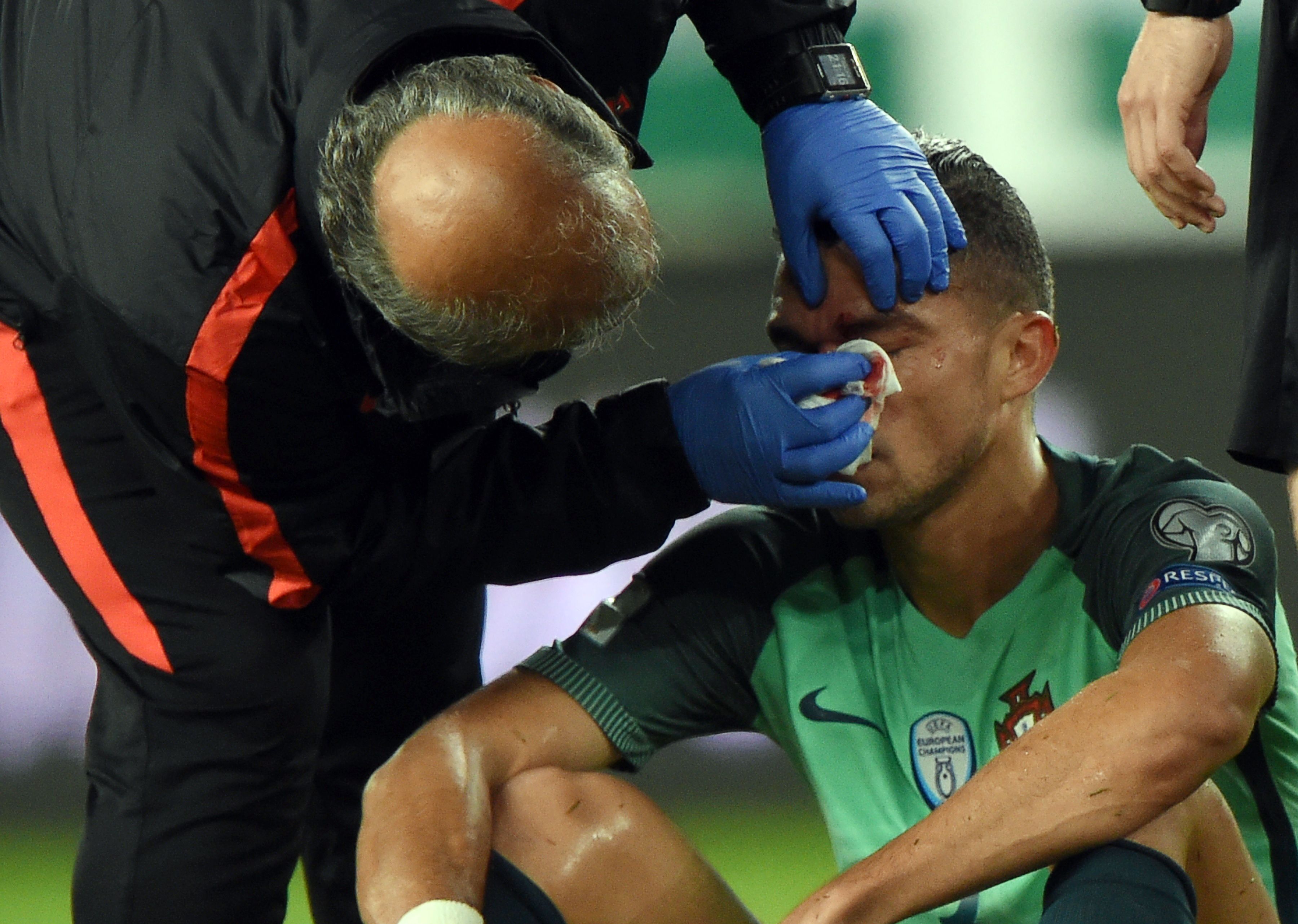 Portugal's Pepe is helped by a doctor during the FIFA World Cup 2018 qualification football match between Hungary and Portugal in Budapest on September 3, 2017. / AFP PHOTO / ATTILA KISBENEDEK (Photo credit should read ATTILA KISBENEDEK/AFP/Getty Images)
