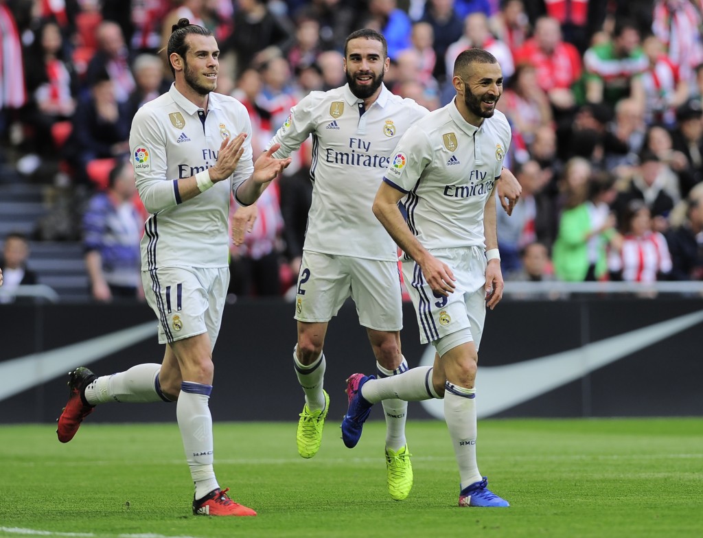 Real Madrid's French forward Karim Benzema (R) celebrates with teammates Welsh forward Gareth Bale (L) and defender Daniel Carvajal (C) after scoring their team's first goal during the Spanish league football match Athletic Club Bilbao vs Real Madrid CF at the San Mames stadium in Bilbao on March 18, 2017. / AFP PHOTO / ANDER GILLENEA (Photo credit should read ANDER GILLENEA/AFP/Getty Images)