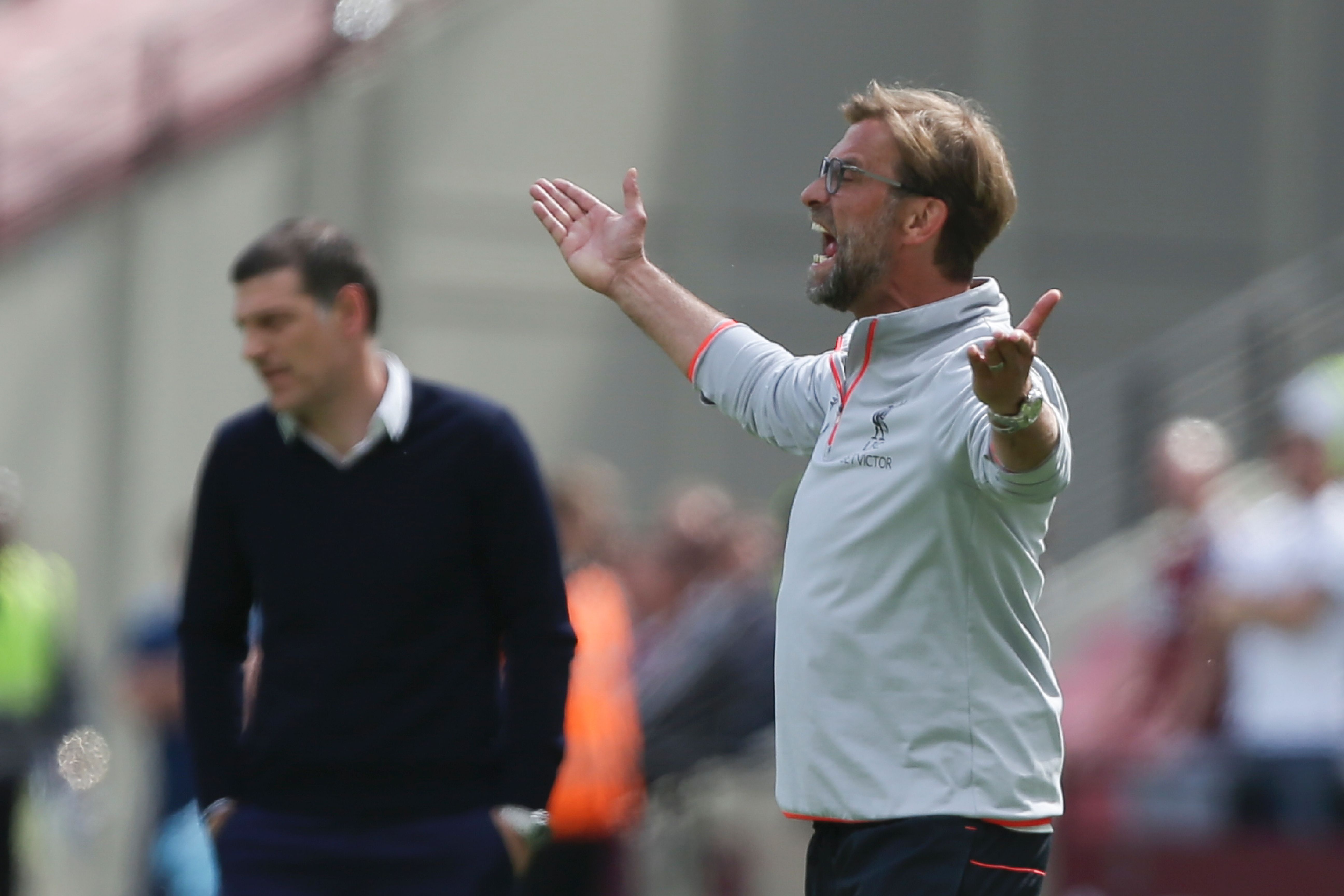 Liverpool's German manager Jurgen Klopp (R) gestures as West Ham United's Croatian manager Slaven Bilic looks on during the English Premier League football match between West Ham United and Liverpool at The London Stadium, in east London on May 14, 2017. / AFP PHOTO / Daniel LEAL-OLIVAS / RESTRICTED TO EDITORIAL USE. No use with unauthorized audio, video, data, fixture lists, club/league logos or 'live' services. Online in-match use limited to 75 images, no video emulation. No use in betting, games or single club/league/player publications. / (Photo credit should read DANIEL LEAL-OLIVAS/AFP/Getty Images)