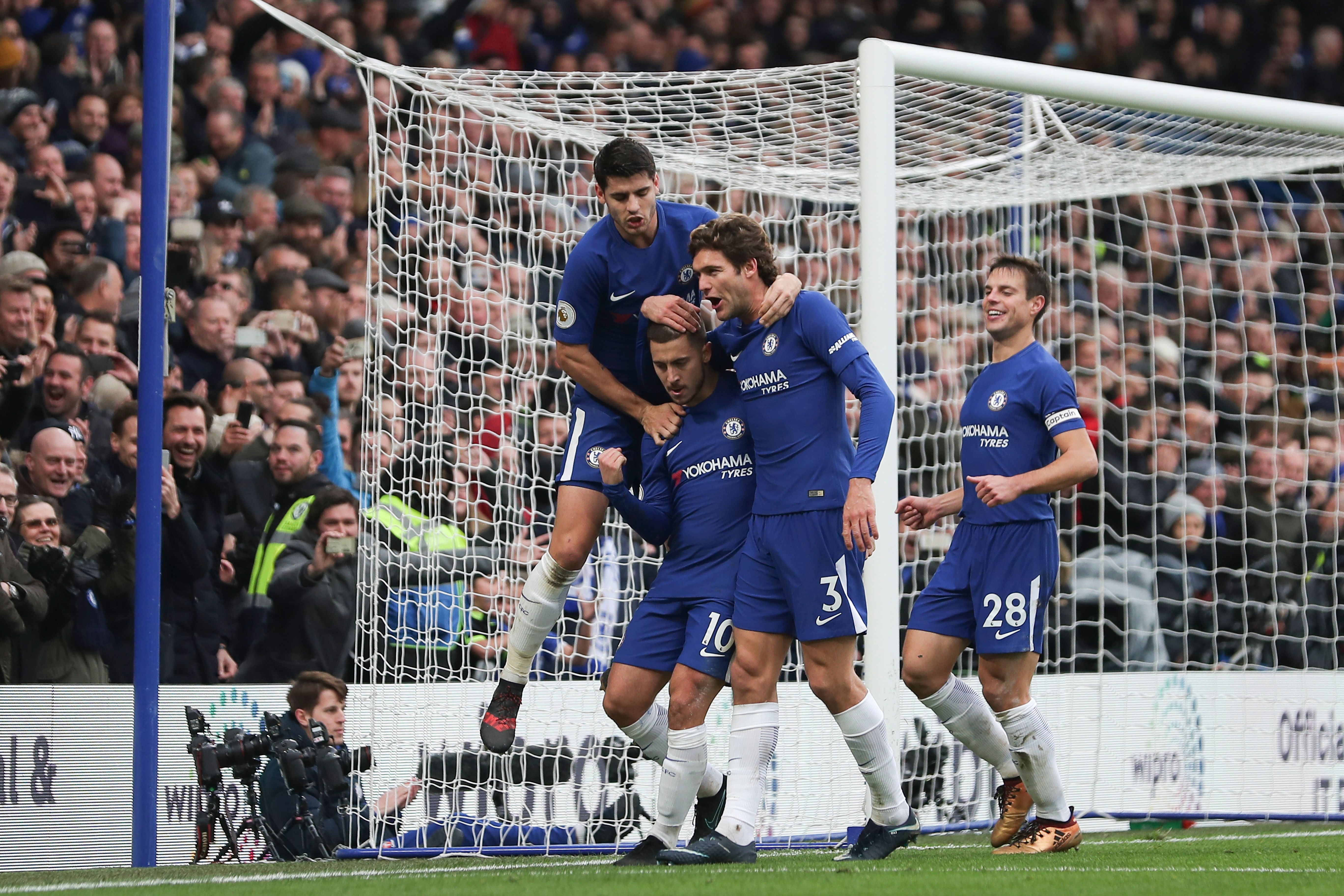 Chelsea's Belgian midfielder Eden Hazard (2L) celebrates with teammates after scoring his team's third goal, and his second goal, from the penalty spot during the English Premier League football match between Chelsea and Newcastle United at Stamford Bridge in London on December 2, 2017. / AFP PHOTO / Daniel LEAL-OLIVAS / RESTRICTED TO EDITORIAL USE. No use with unauthorized audio, video, data, fixture lists, club/league logos or 'live' services. Online in-match use limited to 75 images, no video emulation. No use in betting, games or single club/league/player publications.  /         (Photo credit should read DANIEL LEAL-OLIVAS/AFP/Getty Images)