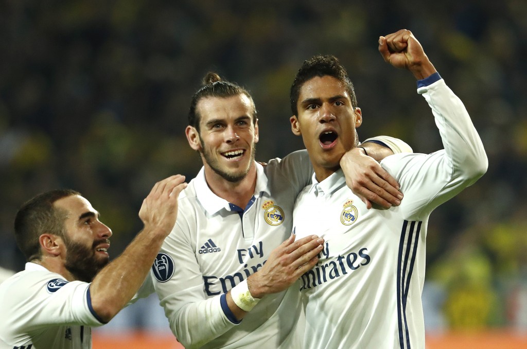 Real Madrid's French defender Raphael Varane (R) reacts after scoring with Real Madrid's Welsh forward Gareth Bale (c) during the UEFA Champions League first leg football match between Borussia Dortmund and Real Madrid at BVB stadium in Dortmund, on September 27, 2016. / AFP / Odd ANDERSEN (Photo credit should read ODD ANDERSEN/AFP/Getty Images)