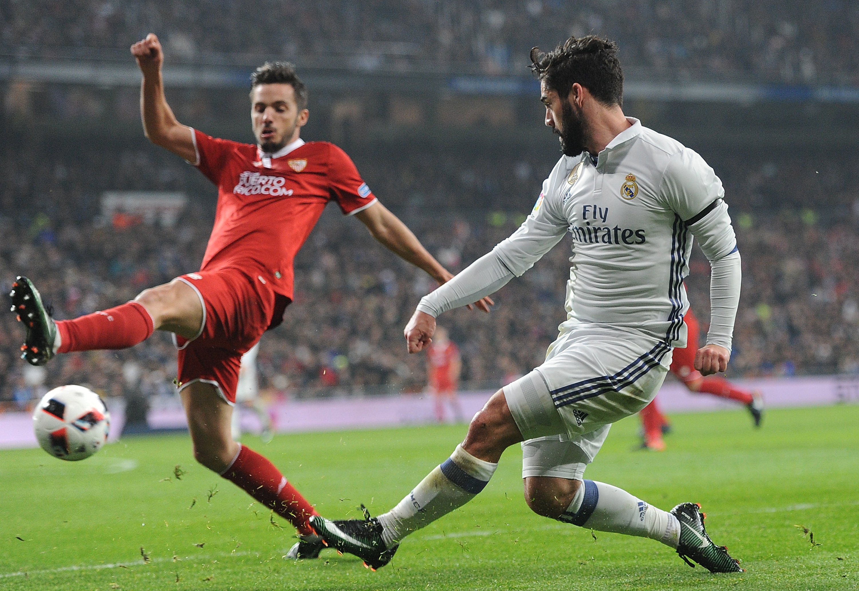 MADRID, SPAIN - JANUARY 04: : Isco Alarcon of Real Madrid crosses the ball past Pablo Sarabia of Sevilla during the Copa del Rey Round of 16 First Leg match between Real Madrid and Sevilla at Bernabeu on January 4, 2017 in Madrid, Spain. (Photo by Denis Doyle/Getty Images)