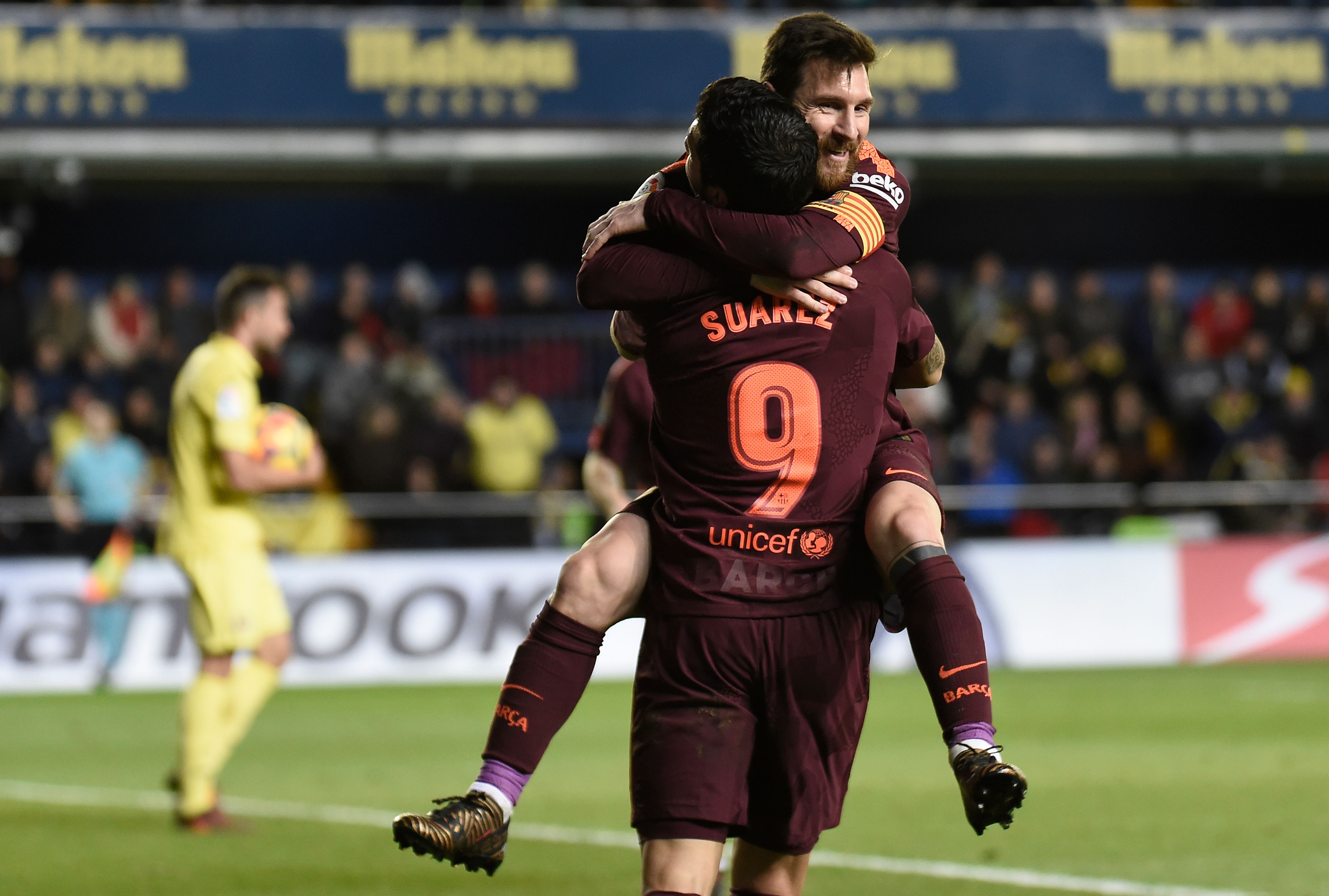 TOPSHOT - Barcelona's Argentinian forward Lionel Messi (L) celebrates  with Barcelona's Uruguayan forward Luis Suarez after scoring during the Spanish league football match between Villarreal CF and FC Barcelona at La Ceramica stadium in Vila-real on December 10, 2017. / AFP PHOTO / JOSE JORDAN        (Photo credit should read JOSE JORDAN/AFP/Getty Images)
