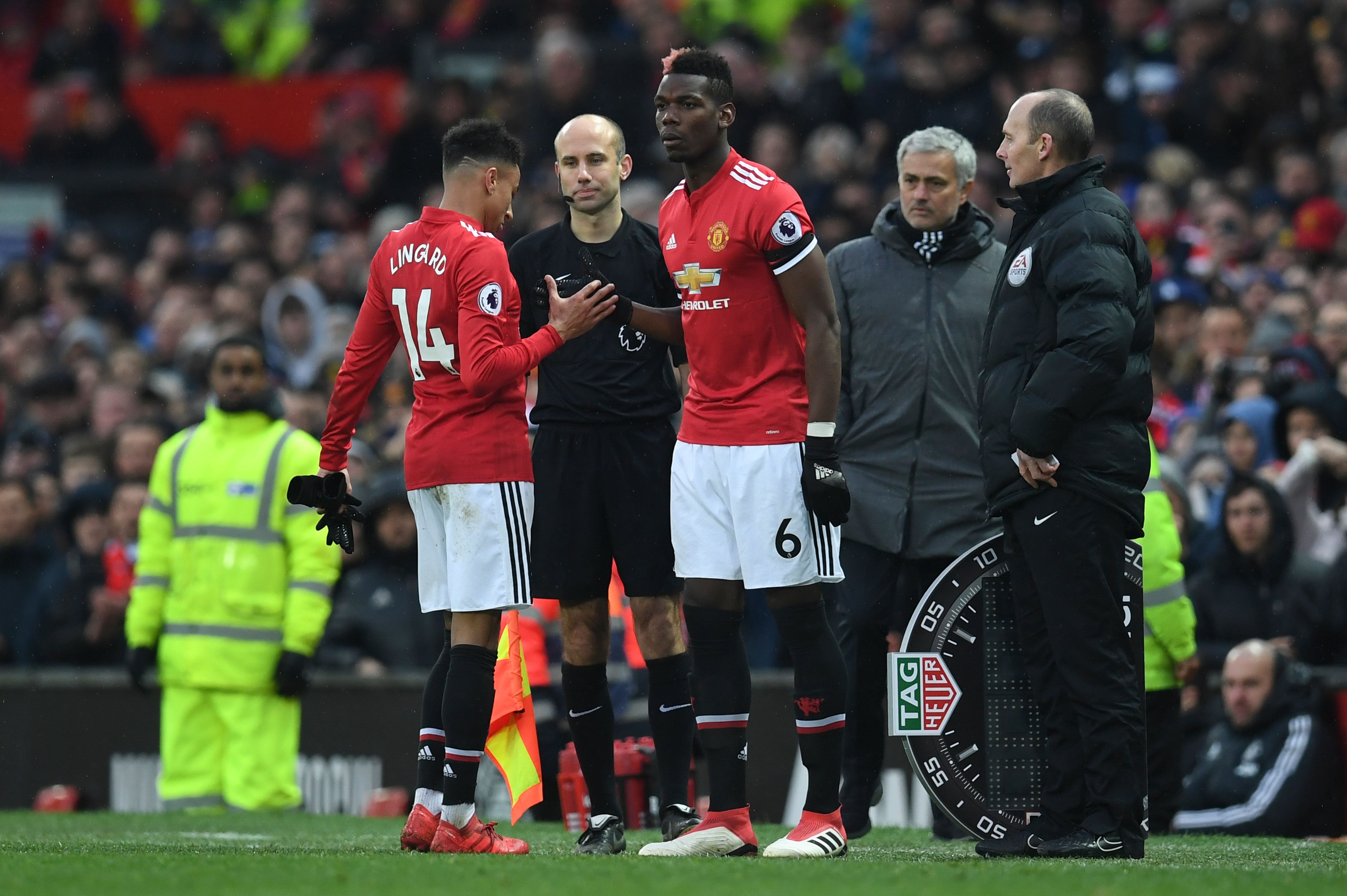 Manchester United's French midfielder Paul Pogba (C) comes on for Manchester United's English midfielder Jesse Lingard (L) during the English Premier League football match between Manchester United and Huddersfield Town at Old Trafford in Manchester, north west England, on February 3, 2018. / AFP PHOTO / Paul ELLIS / RESTRICTED TO EDITORIAL USE. No use with unauthorized audio, video, data, fixture lists, club/league logos or 'live' services. Online in-match use limited to 75 images, no video emulation. No use in betting, games or single club/league/player publications. / (Photo credit should read PAUL ELLIS/AFP/Getty Images)