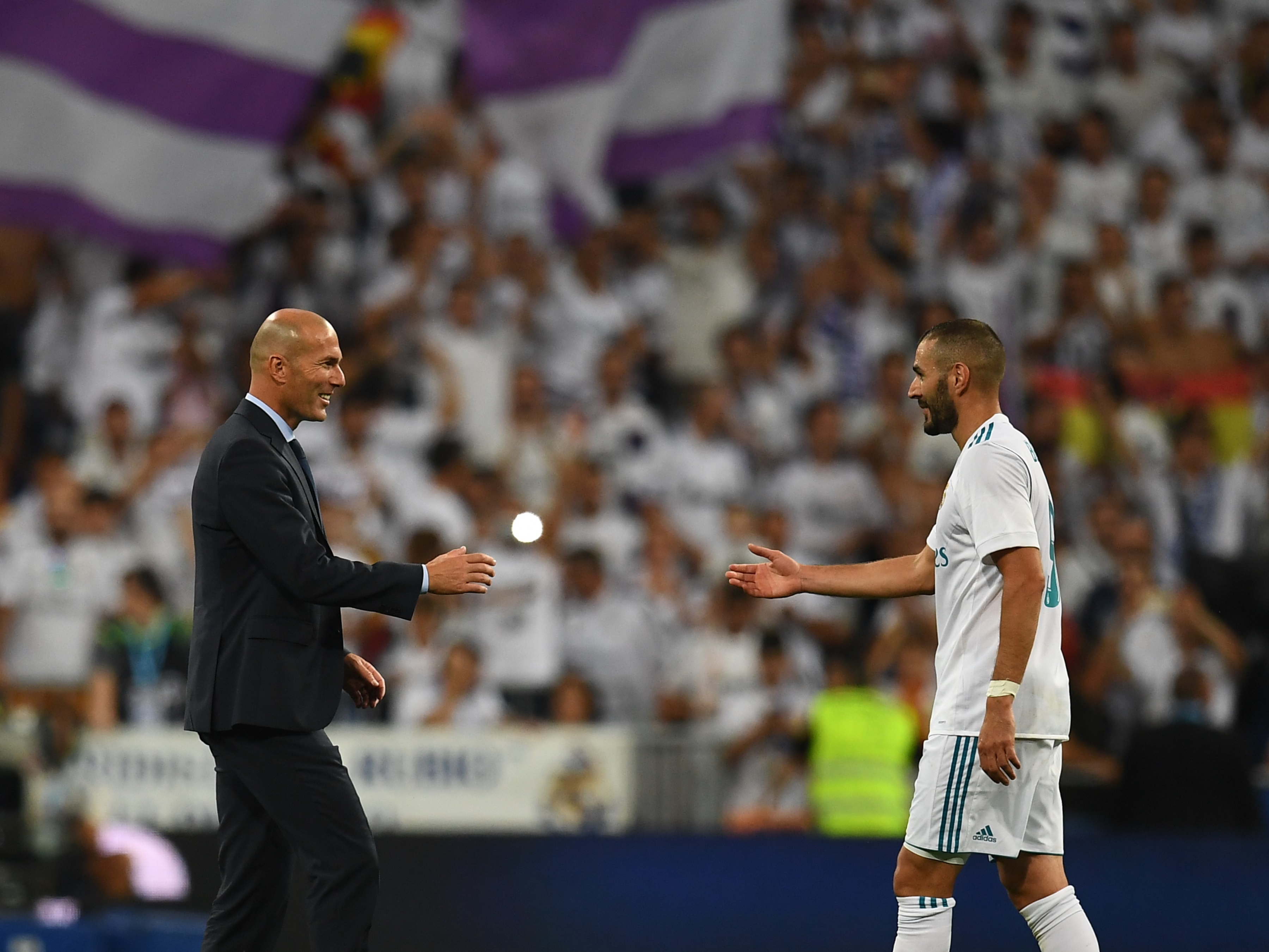 Real Madrid's French coach Zinedine Zidane (L) and Real Madrid's French forward Karim Benzema congratulate each other as they celebrate their Supercup after winning the second leg of the Spanish Supercup football match Real Madrid vs FC Barcelona at the Santiago Bernabeu stadium in Madrid, on August 16, 2017. / AFP PHOTO / GABRIEL BOUYS (Photo credit should read GABRIEL BOUYS/AFP/Getty Images)