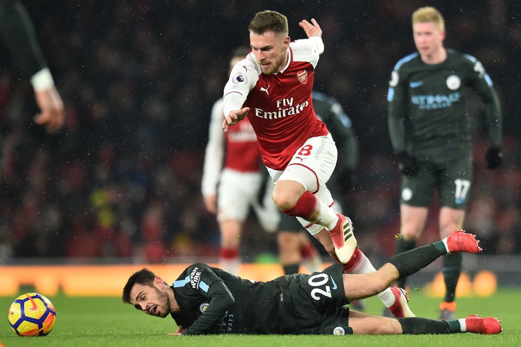 Arsenal's Welsh midfielder Aaron Ramsey (C) vies with Manchester City's Portuguese midfielder Bernardo Silva during the English Premier League football match between Arsenal and Manchester City at the Emirates Stadium in London on March 1, 2018. / AFP PHOTO / Glyn KIRK / RESTRICTED TO EDITORIAL USE. No use with unauthorized audio, video, data, fixture lists, club/league logos or 'live' services. Online in-match use limited to 75 images, no video emulation. No use in betting, games or single club/league/player publications. / (Photo credit should read GLYN KIRK/AFP/Getty Images)