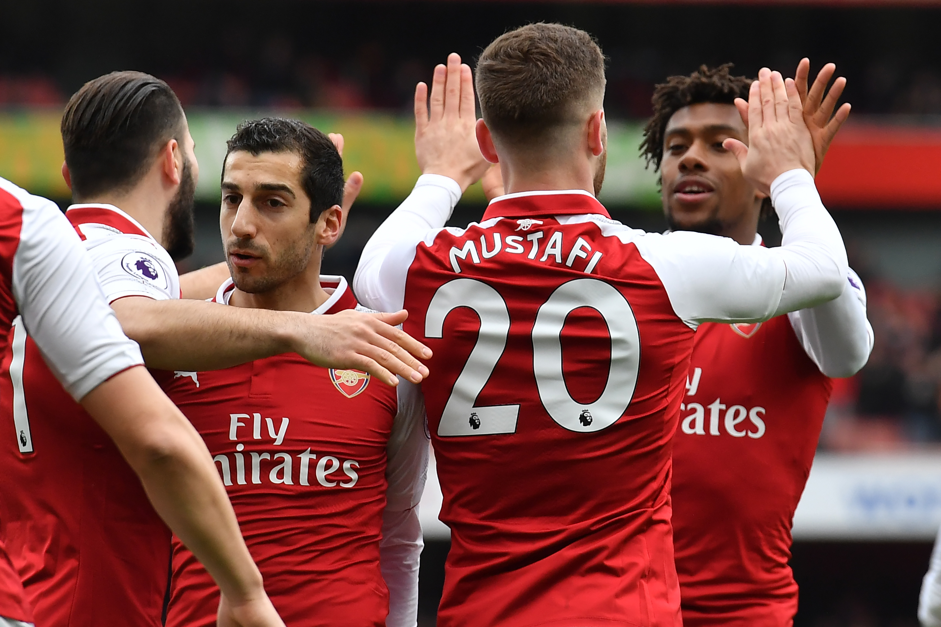 Arsenal's German defender Shkodran Mustafi (2nd R) celebrates with Arsenal's Nigerian striker Alex Iwobi (R) after scoring the opening goal of the English Premier League football match between Arsenal and Watford at the Emirates Stadium in London on March 11, 2018.  / AFP PHOTO / Ben STANSALL / RESTRICTED TO EDITORIAL USE. No use with unauthorized audio, video, data, fixture lists, club/league logos or 'live' services. Online in-match use limited to 75 images, no video emulation. No use in betting, games or single club/league/player publications.  /         (Photo credit should read BEN STANSALL/AFP/Getty Images)