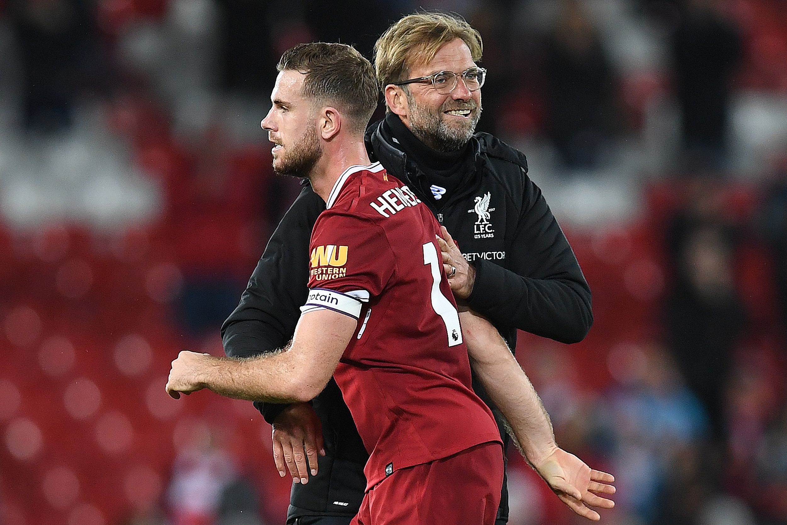 Liverpool's German manager Jurgen Klopp hugs Liverpool's English midfielder Jordan Henderson following the English Premier League football match between Liverpool and Southampton at Anfield in Liverpool, north west England on November 18, 2017. / AFP PHOTO / Paul ELLIS / RESTRICTED TO EDITORIAL USE. No use with unauthorized audio, video, data, fixture lists, club/league logos or 'live' services. Online in-match use limited to 75 images, no video emulation. No use in betting, games or single club/league/player publications. / (Photo credit should read PAUL ELLIS/AFP/Getty Images)