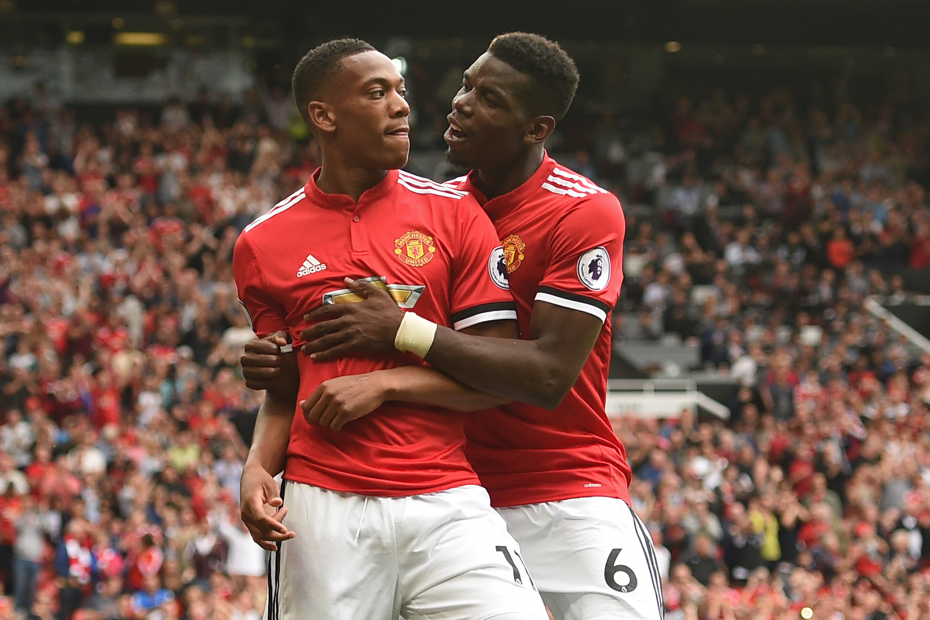 Manchester United's French striker Anthony Martial (L) celebrates with Manchester United's French midfielder Paul Pogba after scoring their third goal during the English Premier League football match between Manchester United and West Ham United at Old Trafford in Manchester, north west England, on August 13, 2017.
Manchester United won the game 4-0. / AFP PHOTO / Oli SCARFF / RESTRICTED TO EDITORIAL USE. No use with unauthorized audio, video, data, fixture lists, club/league logos or 'live' services. Online in-match use limited to 75 images, no video emulation. No use in betting, games or single club/league/player publications. / (Photo credit should read OLI SCARFF/AFP/Getty Images)