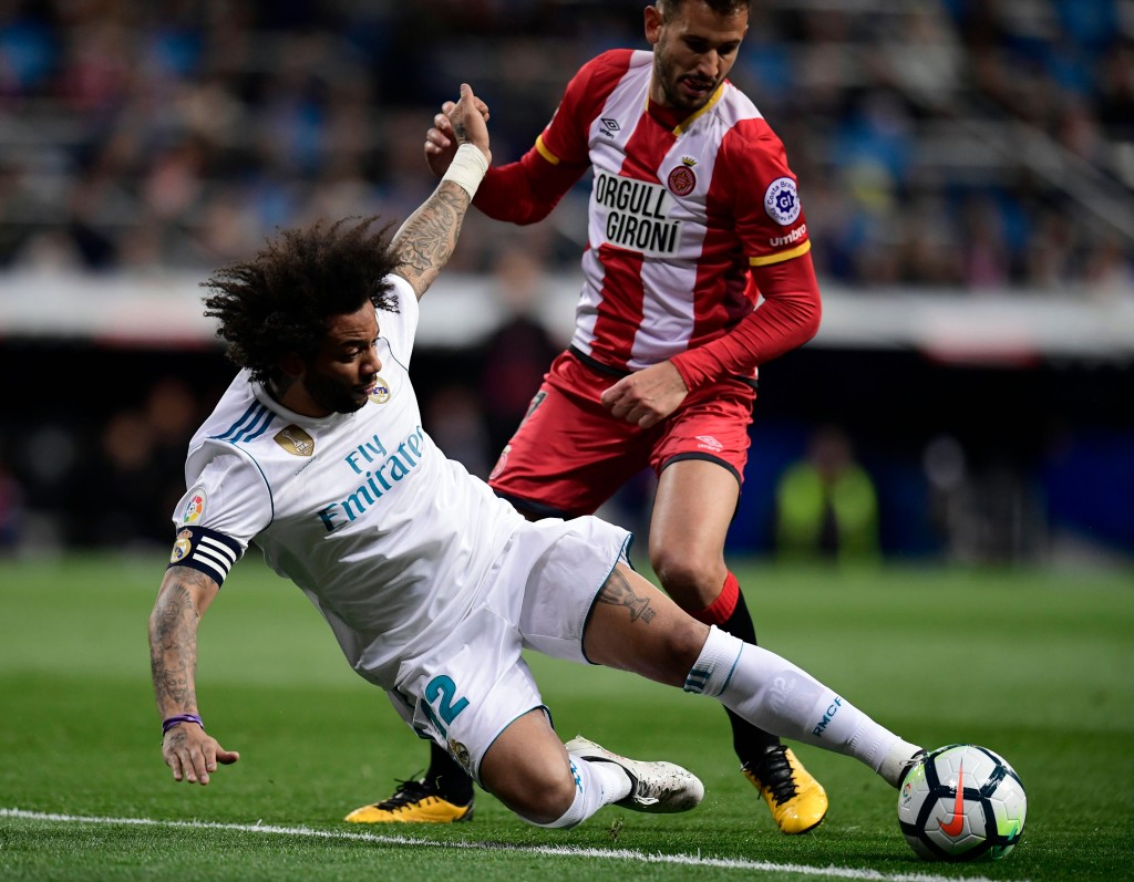 Girona's Uruguayan forward Cristhian Stuani (R) vies with Real Madrid's Brazilian defender Marcelo during the Spanish League football match between Real Madrid CF and Girona FC at the Santiago Bernabeu stadium in Madrid on March 18, 2018. / AFP PHOTO / JAVIER SORIANO (Photo credit should read JAVIER SORIANO/AFP/Getty Images)