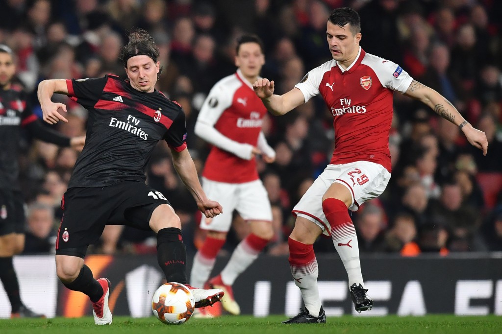 AC Milan's Italian midfielder Riccardo Montolivo (L) vies with Arsenal's Swiss midfielder Granit Xhaka during the UEFA Europa League round of 16 second-leg football match between Arsenal and AC Milan at the Emirates Stadium in London on March 15, 2018. / AFP PHOTO / Ben STANSALL (Photo credit should read BEN STANSALL/AFP/Getty Images)