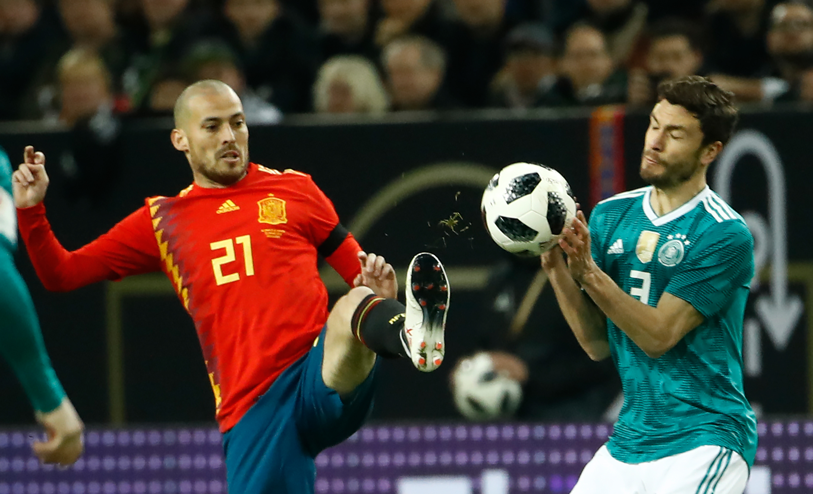 Germany's defender Jonas Hector (R) and Spain's midfielder David Silva (C) vie for the ball during the international friendly football match of Germany vs Spain in Duesseldorf, western Germany, on March 23, 2018, in preparation of the 2018 Fifa World Cup. / AFP PHOTO / Odd ANDERSEN (Photo credit should read ODD ANDERSEN/AFP/Getty Images)