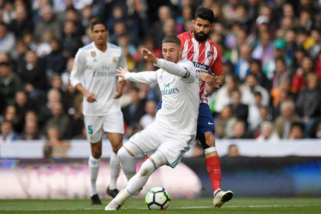 Real Madrid's Spanish defender Sergio Ramos challenges Atletico Madrid's Spanish forward Diego Costa (back R) during the Spanish league football match between Real Madrid CF and Club Atletico de Madrid at the Santiago Bernabeu stadium in Madrid on April 8, 2018. / AFP PHOTO / GABRIEL BOUYS (Photo credit should read GABRIEL BOUYS/AFP/Getty Images)