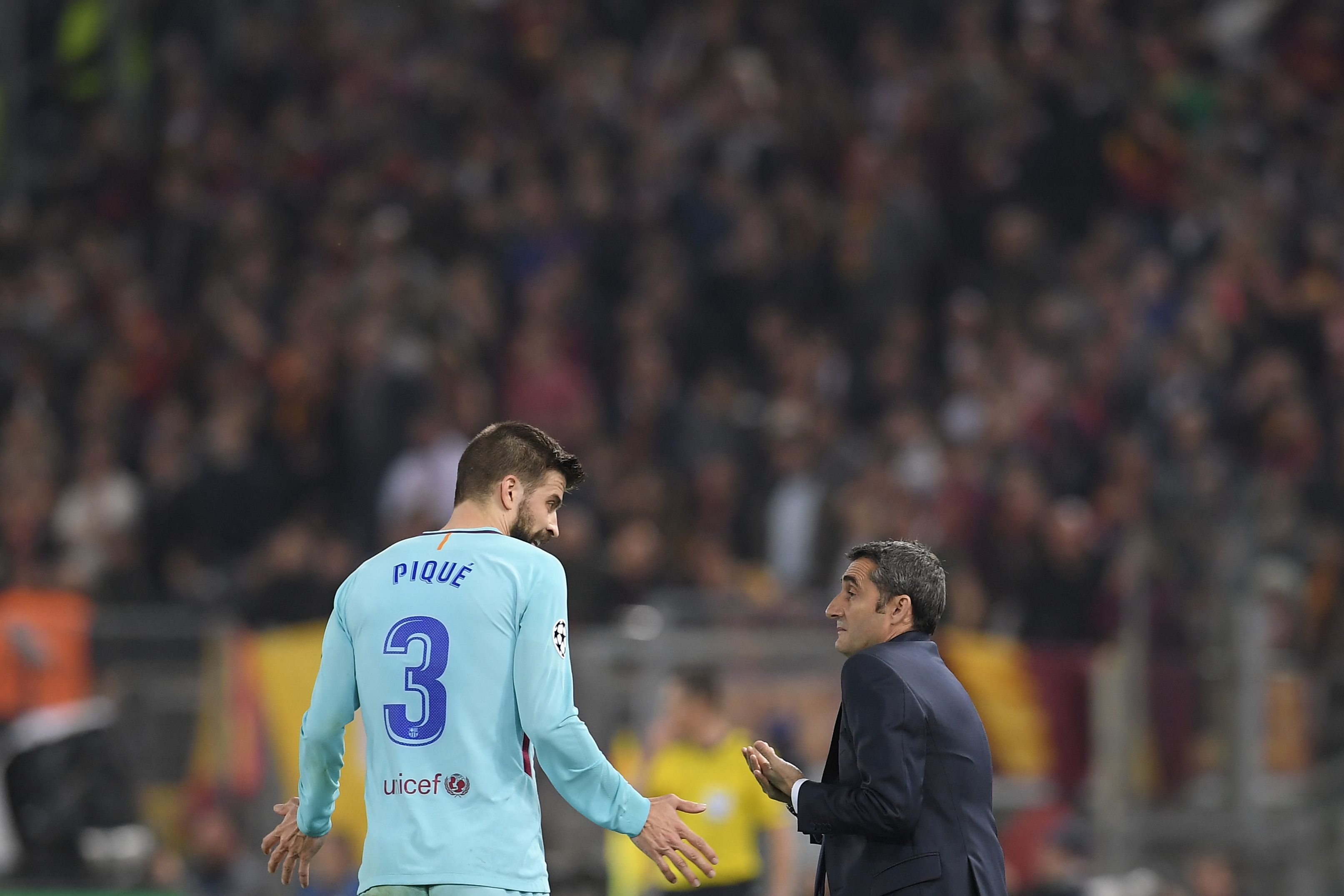 FC Barcelona's Spanish head coach Ernesto Valverde (R) speaks with FC Barcelona's Spanish defender Gerard Pique during the UEFA Champions League quarter-final second leg football match between AS Roma and FC Barcelona at the Olympic Stadium in Rome on April 10, 2018. / AFP PHOTO / LLUIS GENE (Photo credit should read LLUIS GENE/AFP/Getty Images)