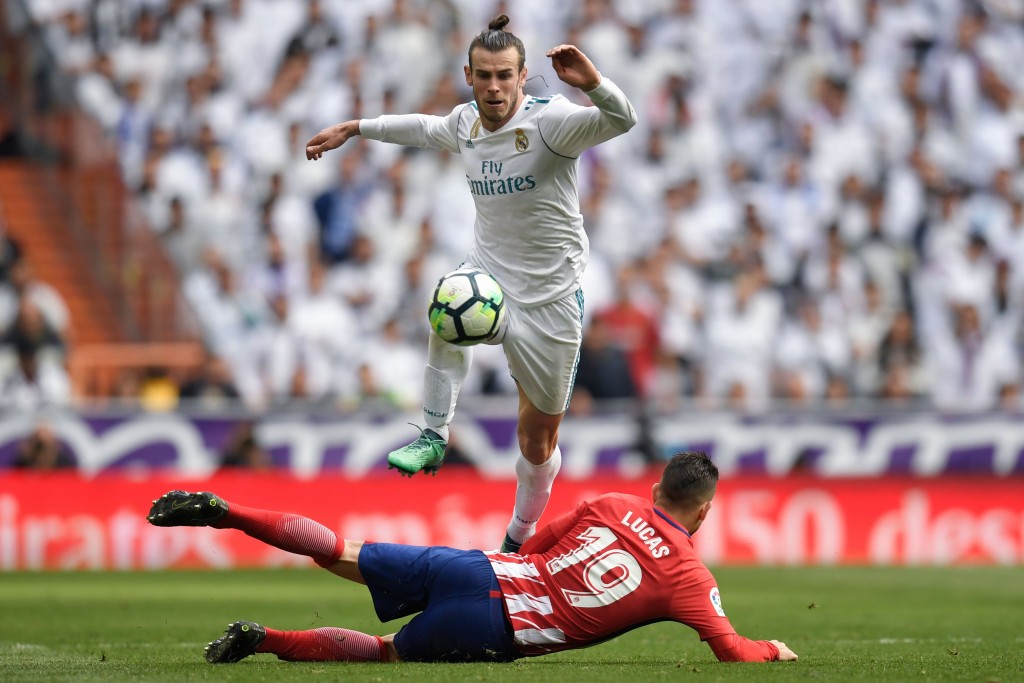 TOPSHOT - Real Madrid's Welsh forward Gareth Bale jumps over Atletico Madrid's French defender Lucas Hernandez (bottom) during the Spanish league football match between Real Madrid CF and Club Atletico de Madrid at the Santiago Bernabeu stadium in Madrid on April 8, 2018. / AFP PHOTO / GABRIEL BOUYS (Photo credit should read GABRIEL BOUYS/AFP/Getty Images)