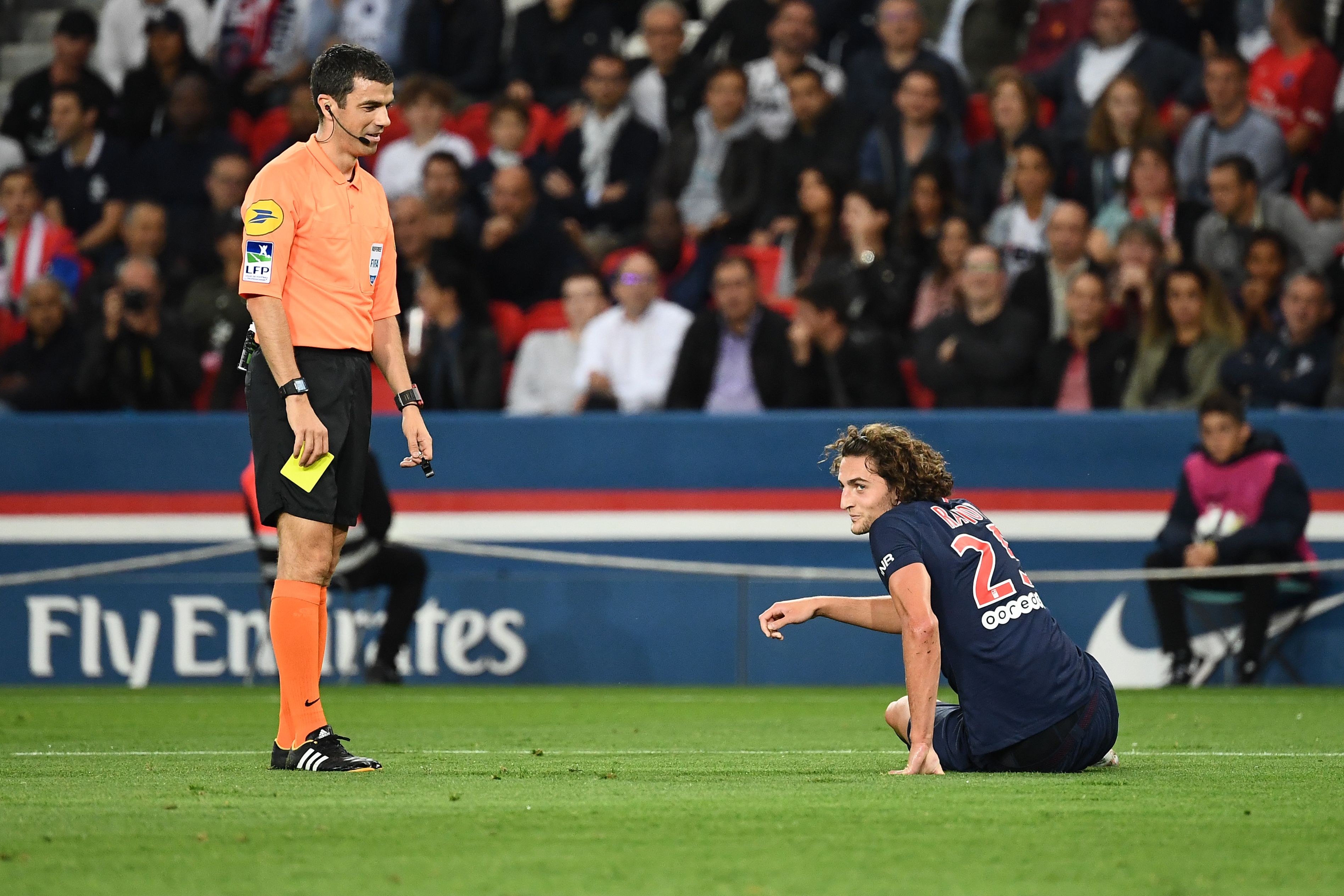 Paris Saint-Germain's French midfielder Adrien Rabiot (R) receives a yellow card from French referee Frank Schneider during the French L1 football match between Paris Saint-Germain (PSG) and Saint-Etienne (ASSE) at the Parc des Princes stadium in Paris on September 14, 2018. (Photo by Anne-Christine POUJOULAT / AFP) (Photo credit should read ANNE-CHRISTINE POUJOULAT/AFP/Getty Images)