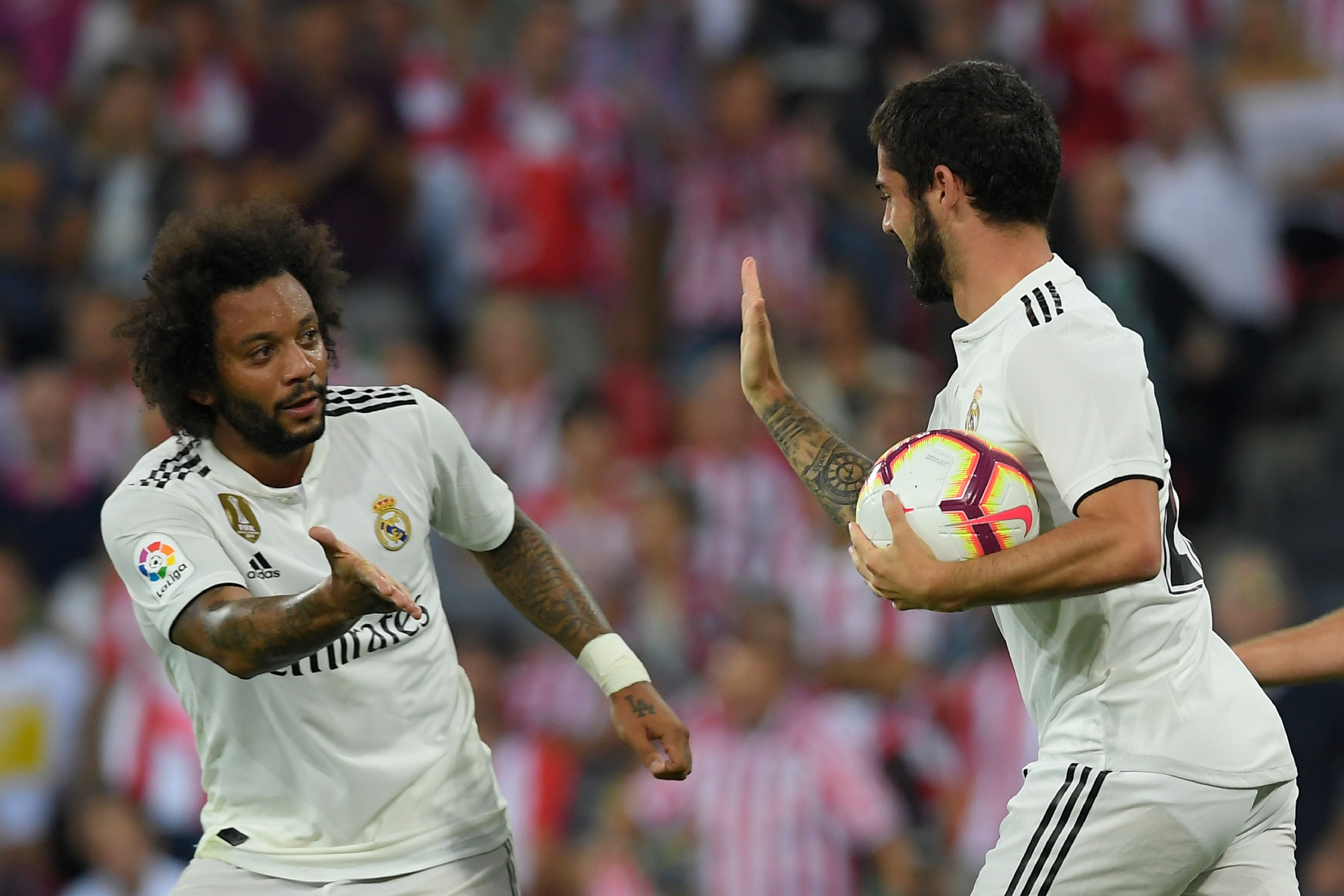 Real Madrid's Spanish midfielder Isco (R) celebrates with Real Madrid's Brazilian defender Marcelo after scoring during the Spanish league football match between Athletic Club Bilbao and Real Madrid CF at the San Mames stadium in Bilbao on September 15, 2018. (Photo by LLUIS GENE / AFP) (Photo credit should read LLUIS GENE/AFP/Getty Images)