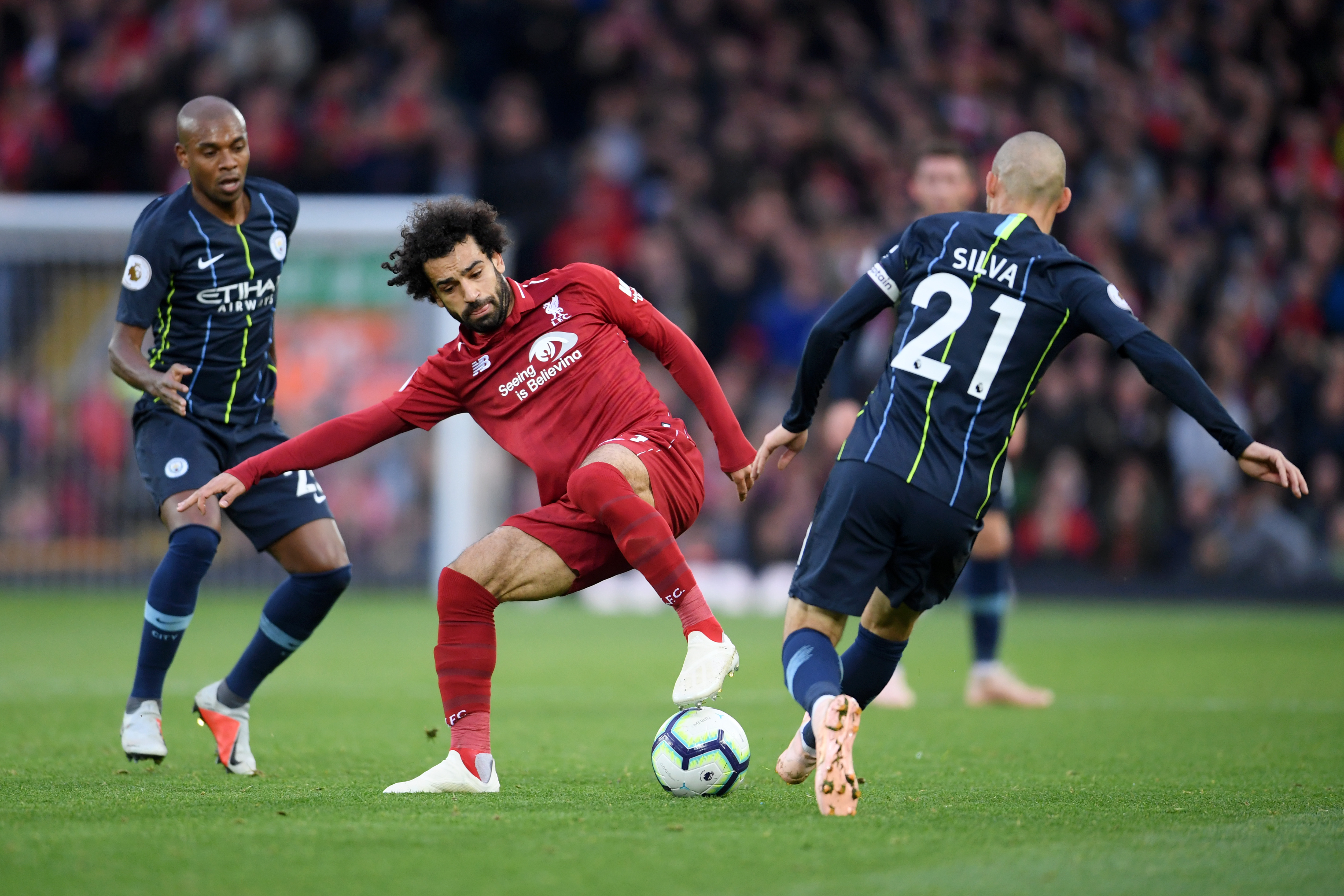 LIVERPOOL, ENGLAND - OCTOBER 07:  Mohamed Salah of Liverpool controls the ball under pressure from Fernandinho and David Silva of Manchester City during the Premier League match between Liverpool FC and Manchester City at Anfield on October 7, 2018 in Liverpool, United Kingdom.  (Photo by Laurence Griffiths/Getty Images)