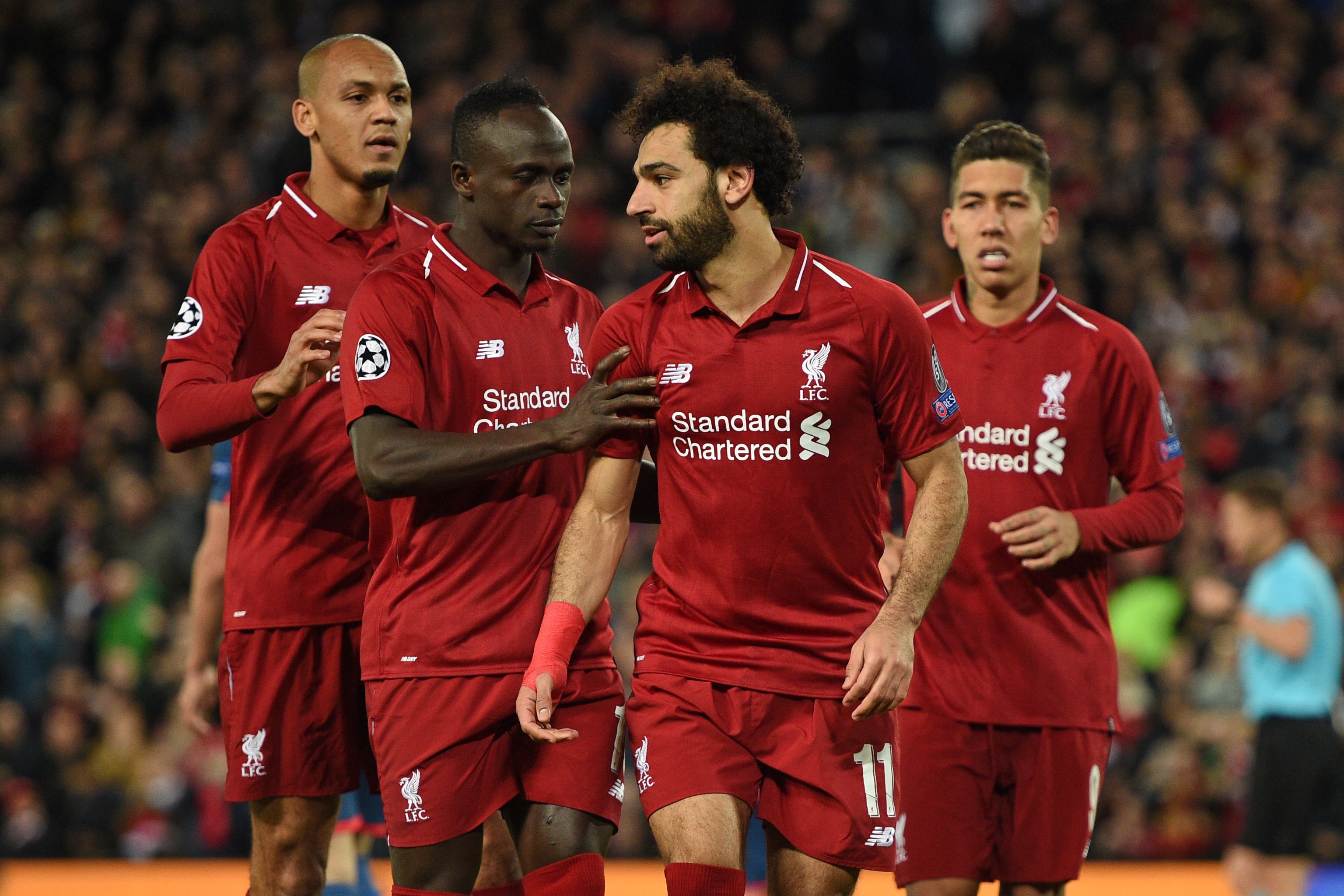 Liverpool's Egyptian midfielder Mohamed Salah (2nd R) celebrates with Liverpool's Senegalese striker Sadio Mane (2nd L) and Liverpool's Brazilian midfielder Fabinho (L) after scoring their third goal from the penalty spot during the UEFA Champions League group C football match between Liverpool and Red Star Belgrade at Anfield in Liverpool, north west England on October 24, 2018. (Photo by Oli SCARFF / AFP) (Photo credit should read OLI SCARFF/AFP/Getty Images)