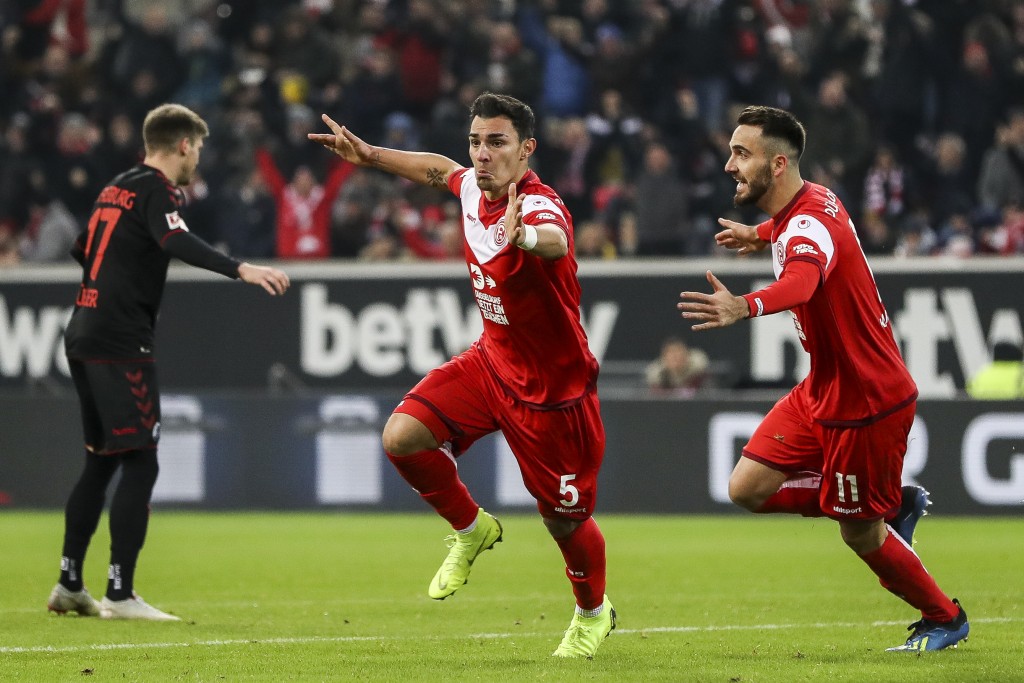 DUESSELDORF, GERMANY - DECEMBER 15: Kaan Ayhan #5 of Fortuna Dusseldorf celebrates with teammate Kenan Karaman after scoring his team's first goal during the Bundesliga match between Fortuna Duesseldorf and Sport-Club Freiburg at Esprit-Arena on December 15, 2018 in Duesseldorf, Germany. (Photo by Maja Hitij/Bongarts/Getty Images)