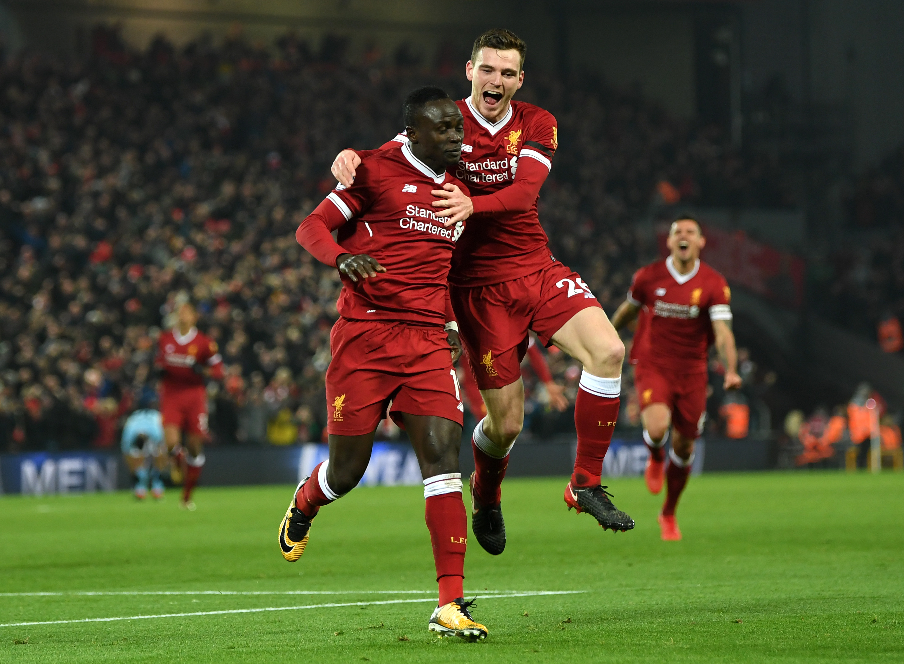 LIVERPOOL, ENGLAND - JANUARY 14: Sadio Mane of Liverpool celebrates with team mate Andy Robertson after scoring the third Liverpool goal during the Premier League match between Liverpool and Manchester City at Anfield on January 14, 2018 in Liverpool, England. (Photo by Shaun Botterill/Getty Images)