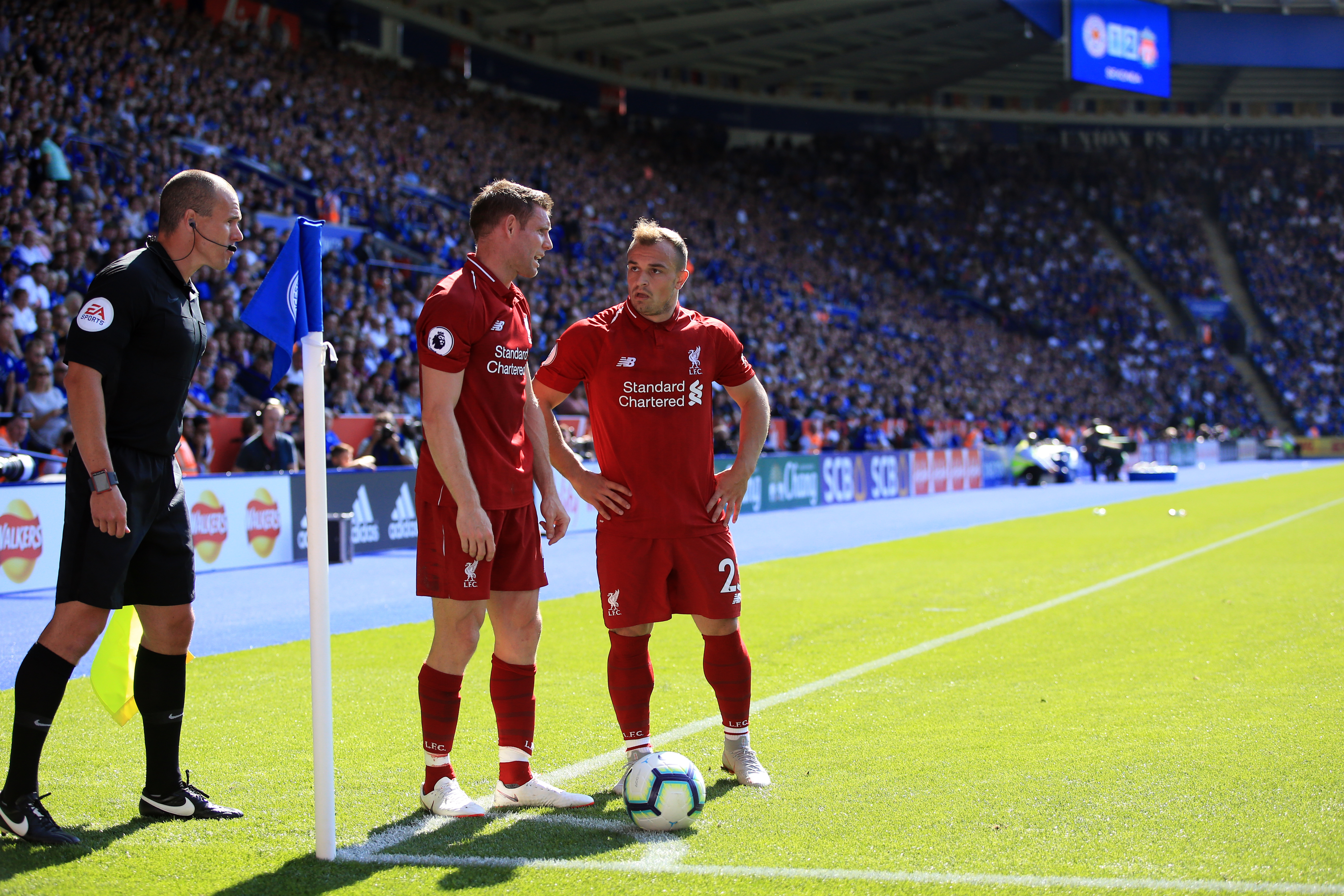 LEICESTER, ENGLAND - SEPTEMBER 01: Xherdan Shaqiri and James Milner of Liverpool in discussion over a corner as the linesman looks on during the Premier League match between Leicester City and Liverpool FC at The King Power Stadium on September 1, 2018 in Leicester, United Kingdom. (Photo by Marc Atkins/Getty Images)