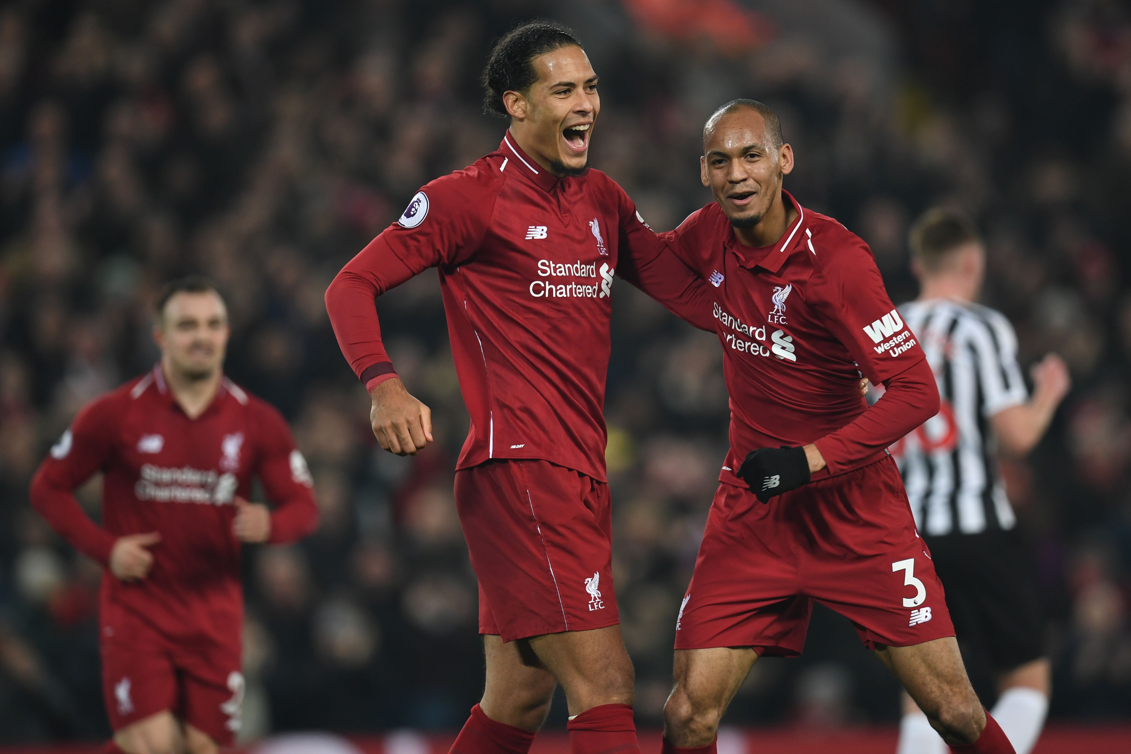 Liverpool's Brazilian midfielder Fabinho (R) celebrates with Liverpool's Dutch defender Virgil van Dijk (C) after scoring their fourth goal during the English Premier League football match between Liverpool and Newcastle United at Anfield in Liverpool, north west England on December 26, 2018. - Liverpool won the game 4-0. (Photo by Paul ELLIS / AFP) / RESTRICTED TO EDITORIAL USE. No use with unauthorized audio, video, data, fixture lists, club/league logos or 'live' services. Online in-match use limited to 120 images. An additional 40 images may be used in extra time. No video emulation. Social media in-match use limited to 120 images. An additional 40 images may be used in extra time. No use in betting publications, games or single club/league/player publications. / (Photo credit should read PAUL ELLIS/AFP/Getty Images)