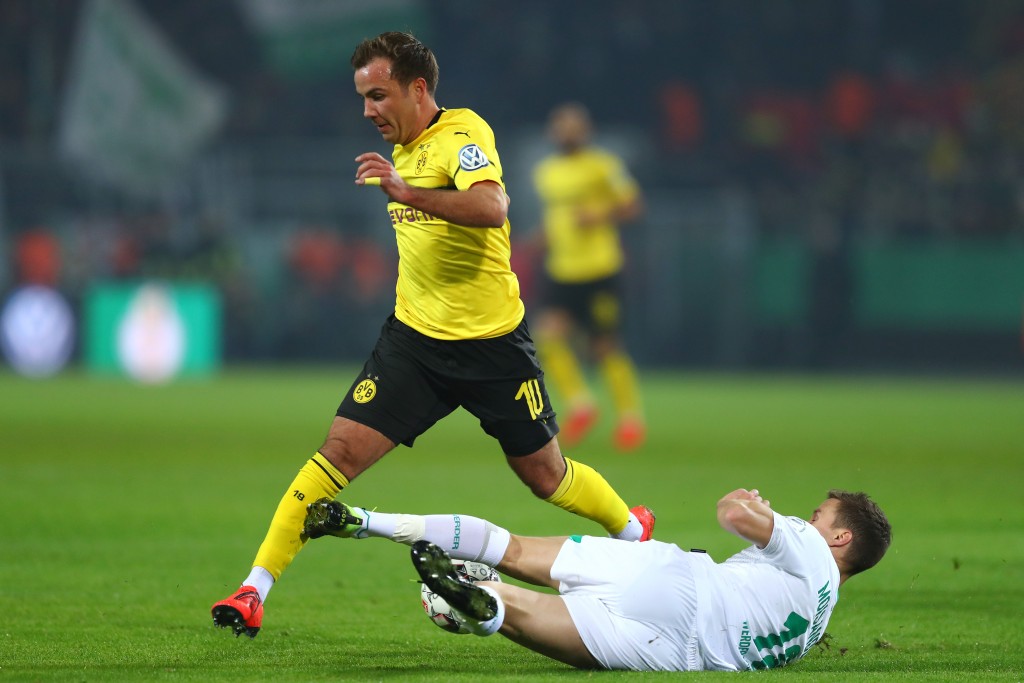 DORTMUND, GERMANY - FEBRUARY 05: Niklas Moisander of Werder Bremen tackles Mario Gotze of Borussia Dortmund during the DFB Cup match between Borussia Dortmund and Werder Bremen at Signal Iduna Park on February 5, 2019 in Dortmund, Germany. (Photo by Lars Baron/Bongarts/Getty Images)