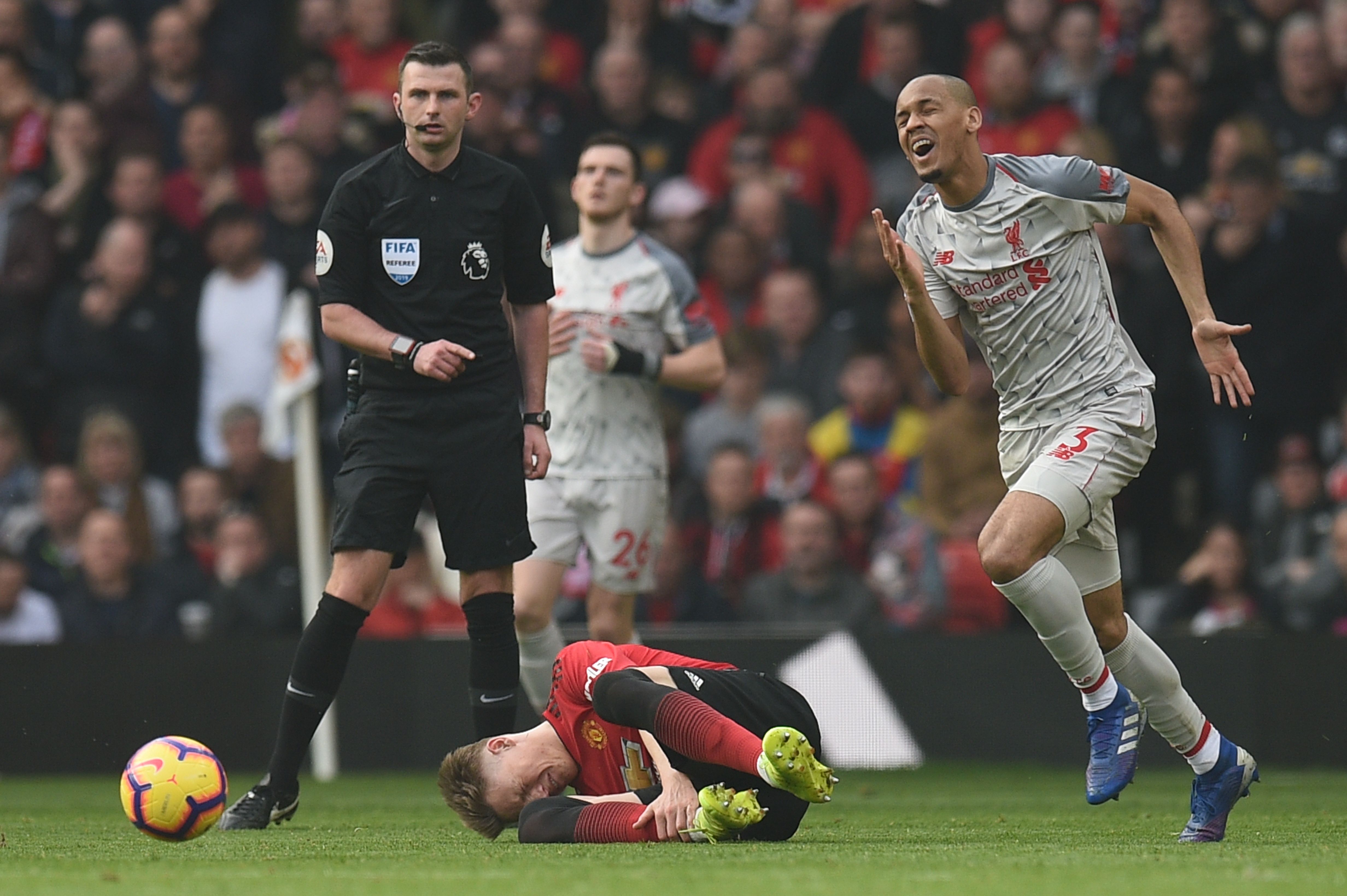 Manchester United's English midfielder Scott McTominay (C) goes down after being fouled during the English Premier League football match between Manchester United and Liverpool at Old Trafford in Manchester, north west England, on February 24, 2019. (Photo by Oli SCARFF / AFP) / RESTRICTED TO EDITORIAL USE. No use with unauthorized audio, video, data, fixture lists, club/league logos or 'live' services. Online in-match use limited to 120 images. An additional 40 images may be used in extra time. No video emulation. Social media in-match use limited to 120 images. An additional 40 images may be used in extra time. No use in betting publications, games or single club/league/player publications. /         (Photo credit should read OLI SCARFF/AFP/Getty Images)