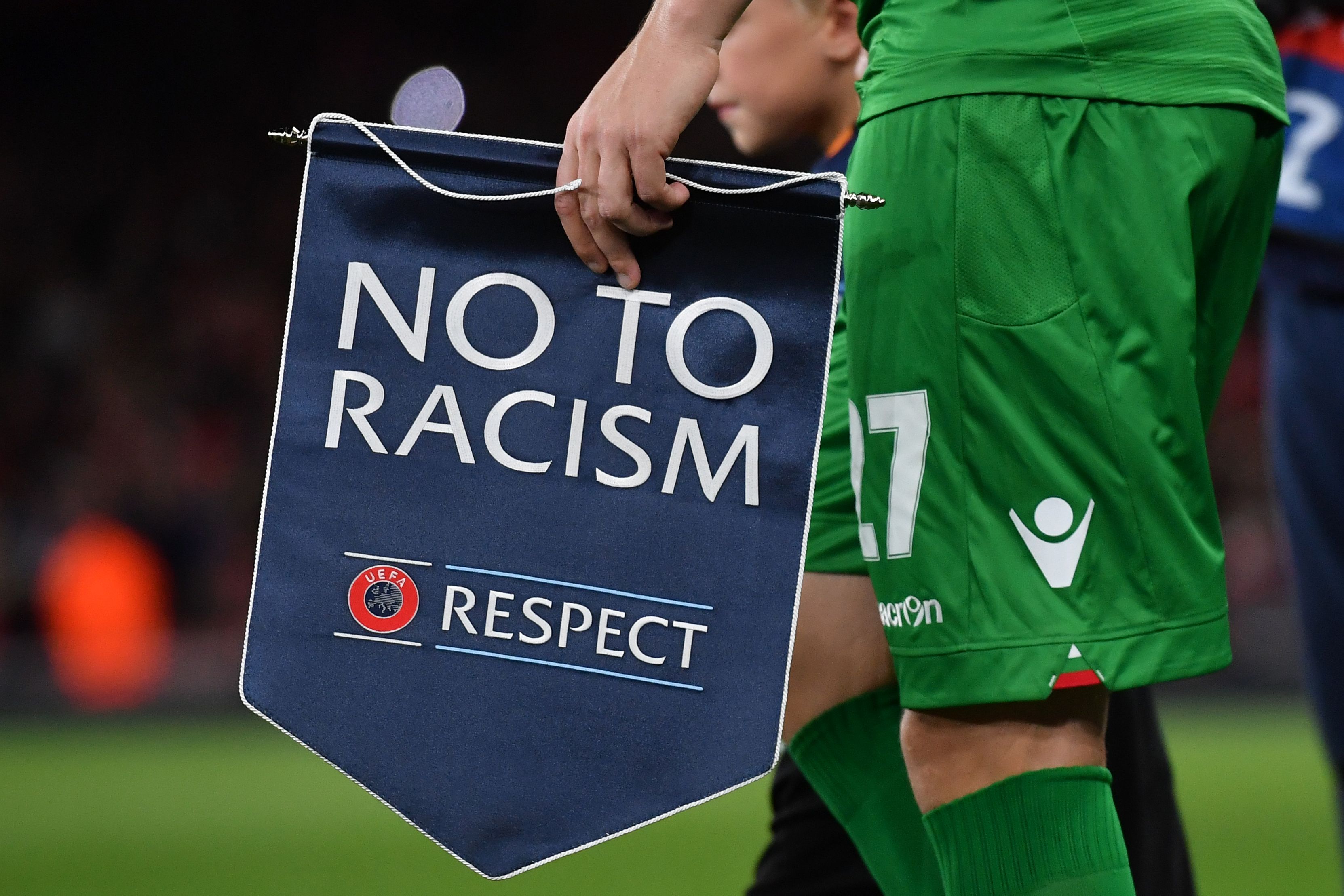 Ludogorets' Romanian defender Cosmin Moti holds an anti-racism banner ahead of the UEFA Champions League Group A football match between Arsenal and Ludogorets Razgrad at The Emirates Stadium in London on October 19, 2016. / AFP / BEN STANSALL (Photo credit should read BEN STANSALL/AFP/Getty Images)