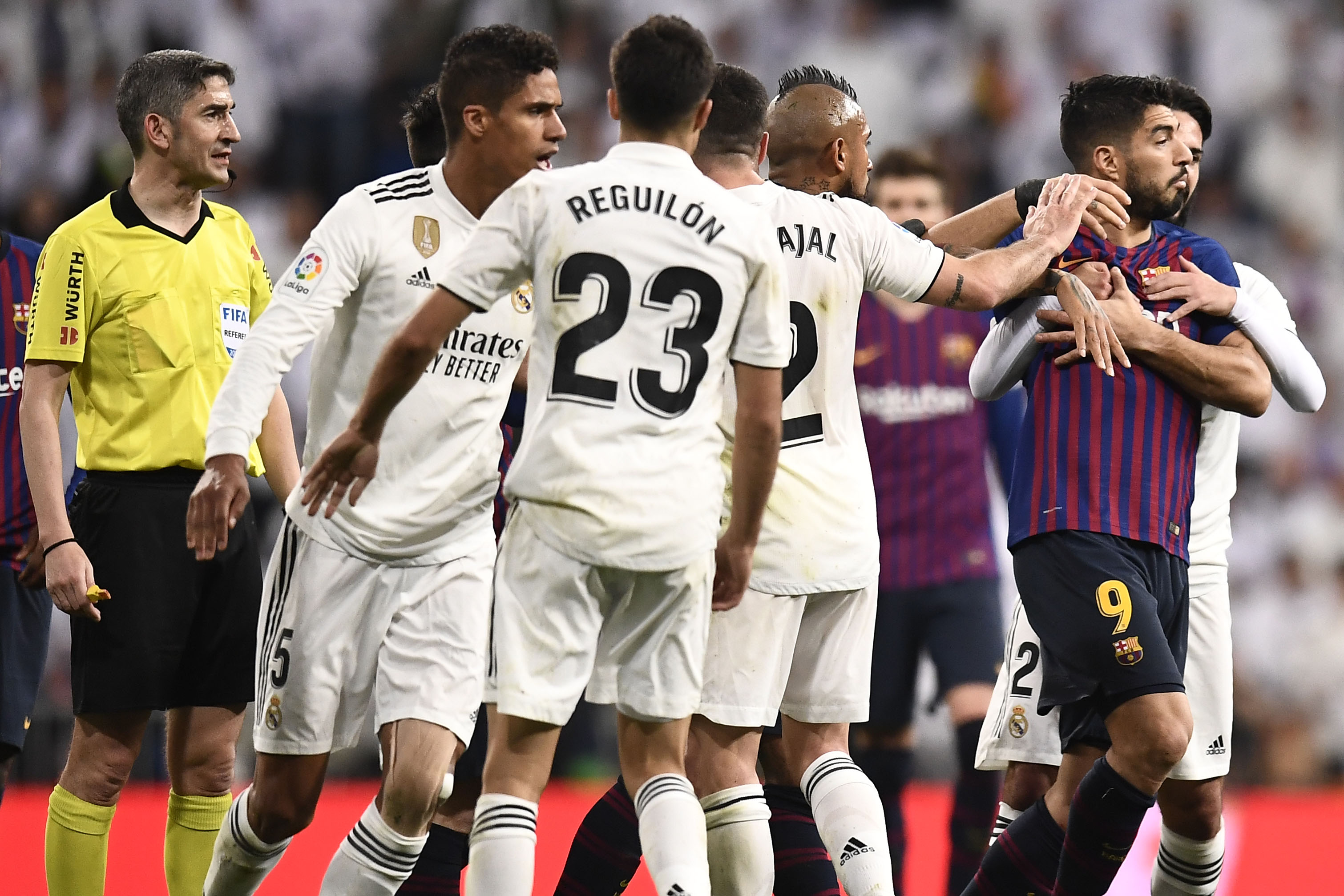 Barcelona's Uruguayan forward Luis Suarez (2R) is hold by Real Madrid's Spanish midfielder Isco (R) during the Spanish league football match between Real Madrid CF and FC Barcelona at the Santiago Bernabeu stadium in Madrid on March 2, 2019. (Photo by OSCAR DEL POZO / AFP) (Photo credit should read OSCAR DEL POZO/AFP/Getty Images)
