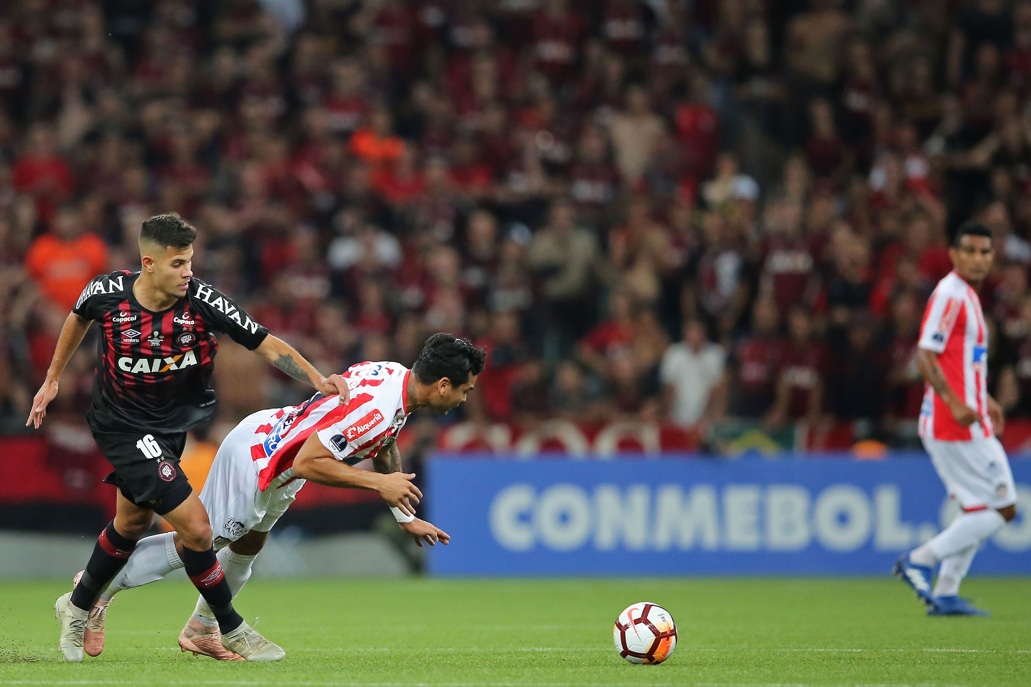 Bruno Guimaraes (L) of Brazils Atletico Paranaense vies for the ball with Jeferson Gomez of Colombia's Junior during the 2018 Copa Sudamericana second leg final football match at the Arena da Baixada stadium in Curitiba, Brazil, on December 12, 2018. (Photo by Heuler Andrey / AFP) (Photo credit should read HEULER ANDREY/AFP/Getty Images)