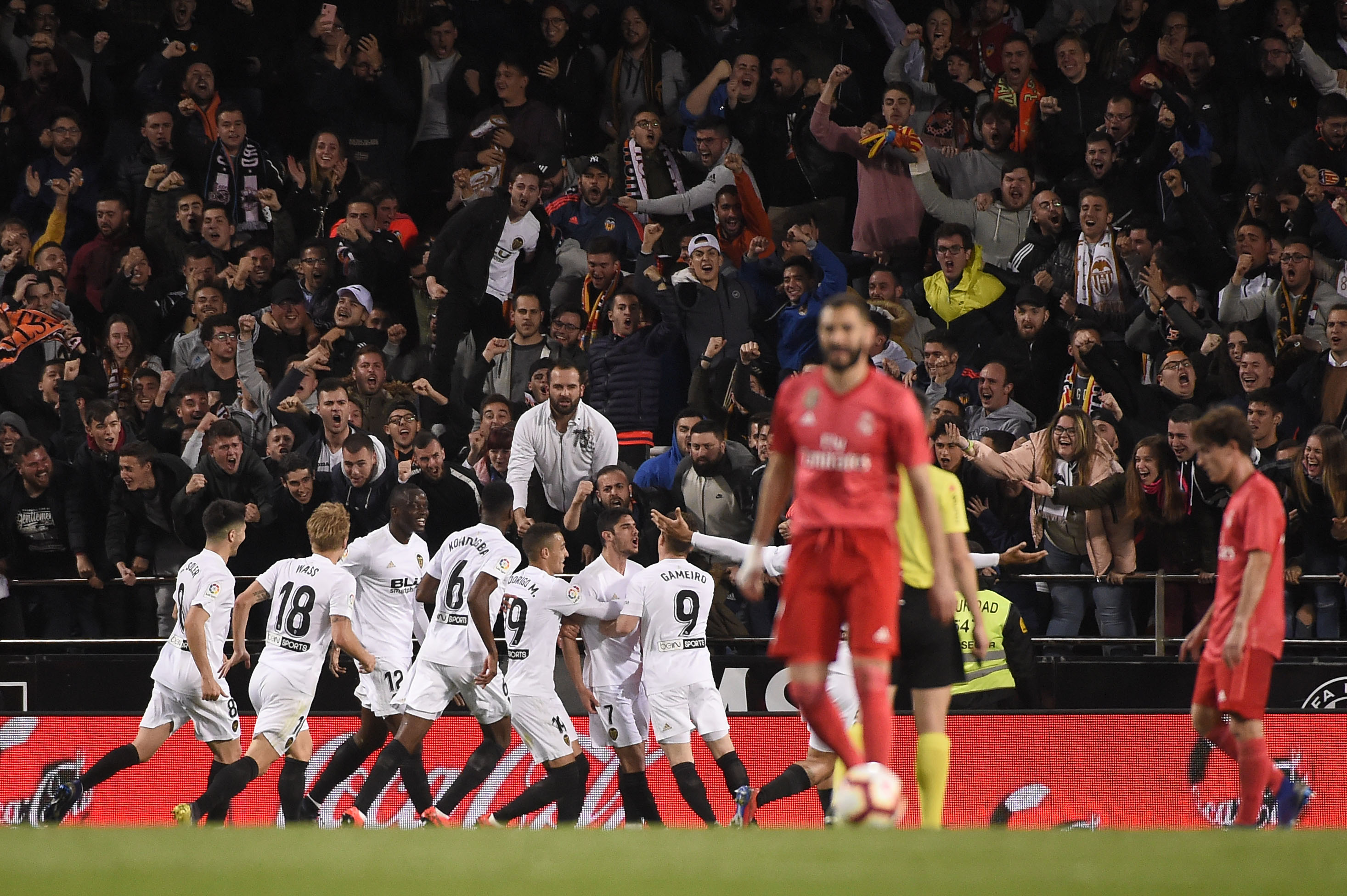 Valencia players gather to celebrate the opening goal during the Spanish league football match between Valencia CF and Real Madrid CF at the Mestalla stadium in Valencia on April 3, 2019. (Photo by JOSE JORDAN / AFP)        (Photo credit should read JOSE JORDAN/AFP/Getty Images)