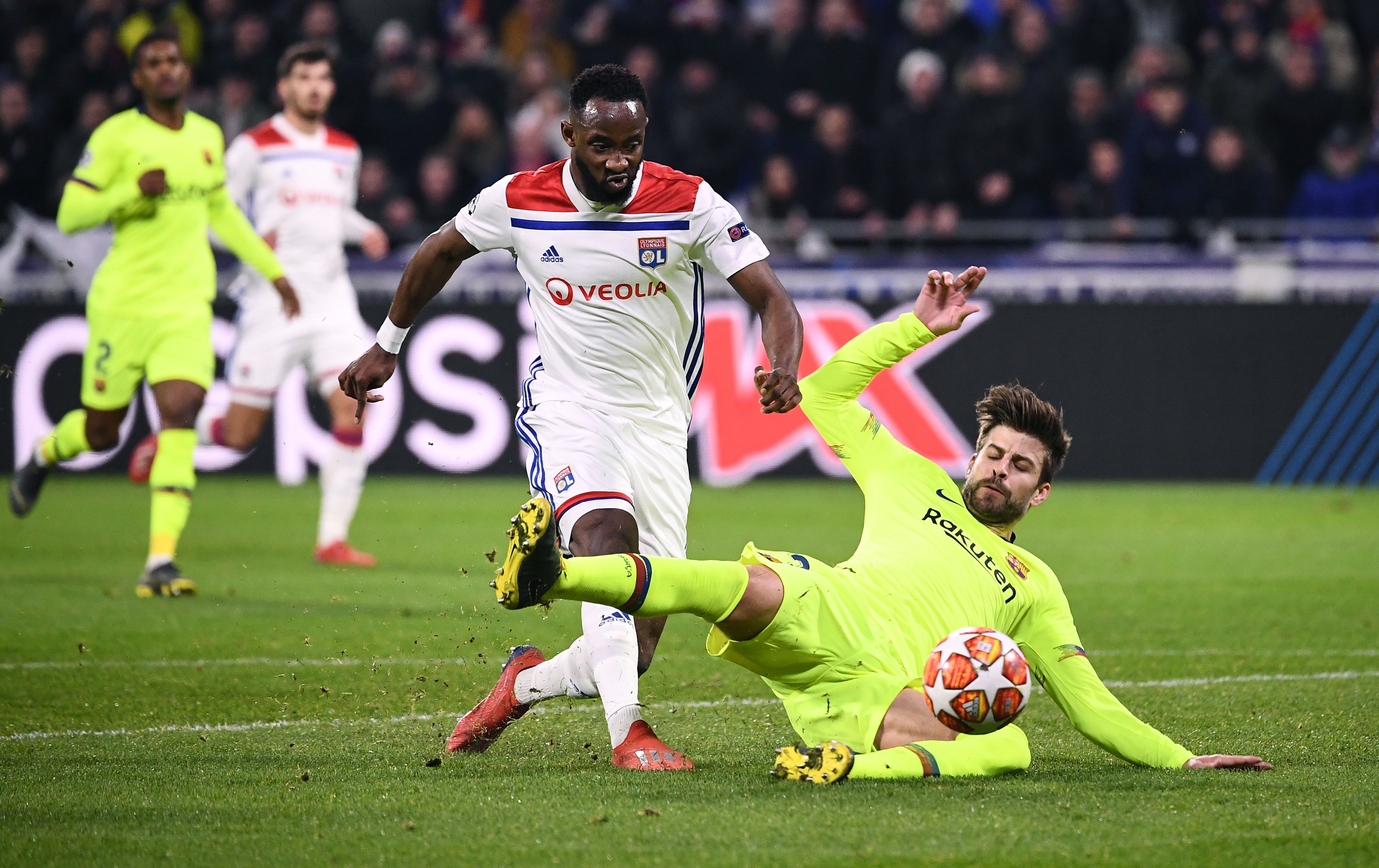 Lyon's French forward Moussa Dembele (L) shoots the ball next to Barcelona's Spanish defender Gerard Pique (R) during the UEFA Champions League round of 16 first leg football match between Lyon (OL) and FC Barcelona on February 19, 2019, at the Groupama Stadium in Decines-Charpieu, central-eastern France. (Photo by FRANCK FIFE / AFP) (Photo credit should read FRANCK FIFE/AFP/Getty Images)