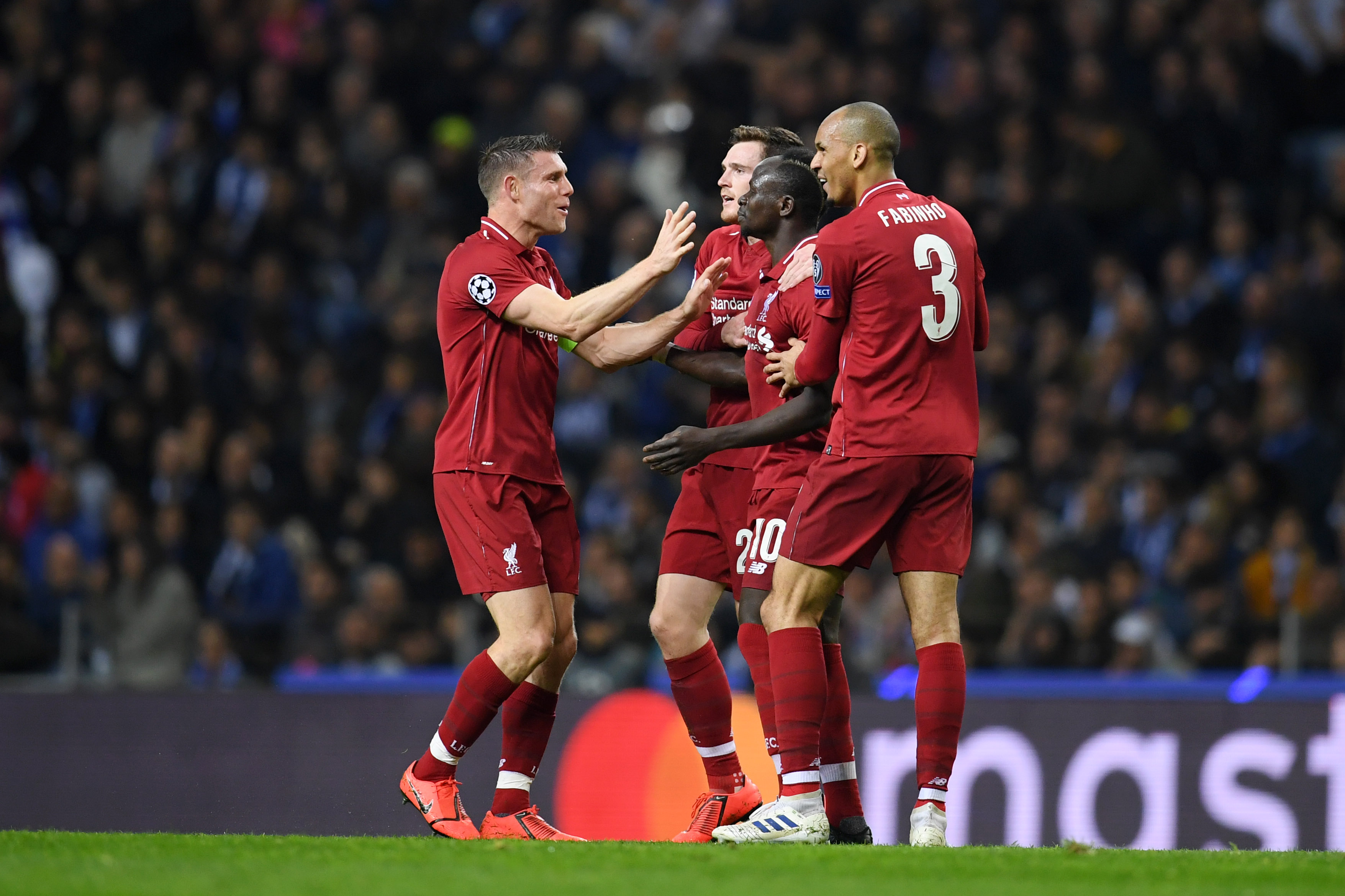 PORTO, PORTUGAL - APRIL 17: Sadio Mane of Liverpool celebrates with teammates James Milner, Andy Robertson and Fabinho of Liverpool after scoring his team's first goal during the UEFA Champions League Quarter Final second leg match between Porto and Liverpool at Estadio do Dragao on April 17, 2019 in Porto, Portugal. (Photo by Matthias Hangst/Getty Images)