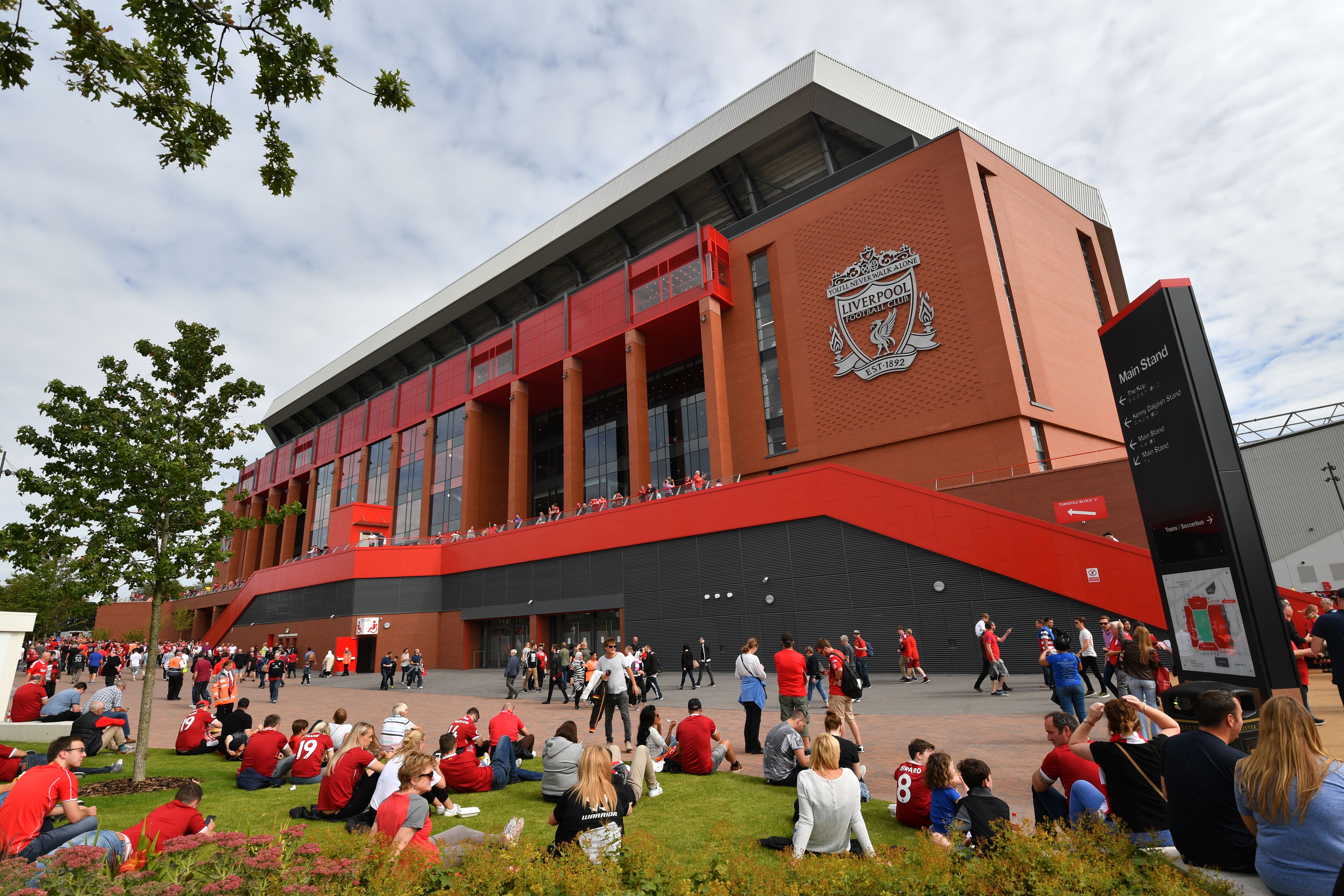 Fans gather outside the stadium in the sunshine ahead of the English Premier League football match between Liverpool and Arsenal at Anfield in Liverpool, north west England on August 27, 2017. / AFP PHOTO / Anthony DEVLIN / RESTRICTED TO EDITORIAL USE. No use with unauthorized audio, video, data, fixture lists, club/league logos or 'live' services. Online in-match use limited to 75 images, no video emulation. No use in betting, games or single club/league/player publications.  /         (Photo credit should read ANTHONY DEVLIN/AFP/Getty Images)