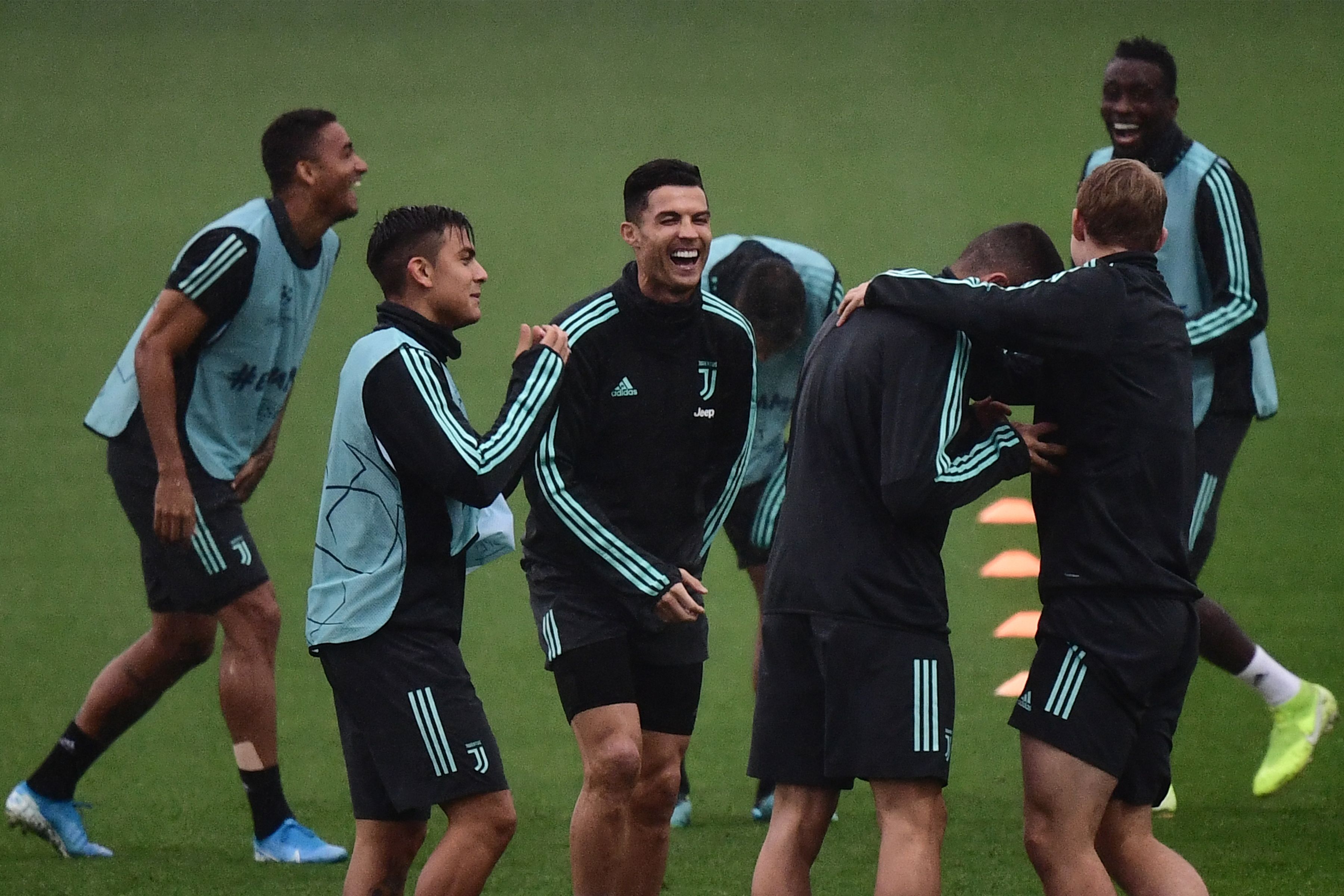 Juventus' Portuguese forward Cristiano Ronaldo (C) jokes with Juventus' Argentine forward Paulo Dybala (2ndL) and teammates during a training session on October 21, 2019 at the Juventus Continassa Training Center in Turin, on the eve of Juventus' UEFA Champions League stage Group D match against Lokomotiv Moscow. (Photo by Marco Bertorello / AFP) (Photo by MARCO BERTORELLO/AFP via Getty Images)