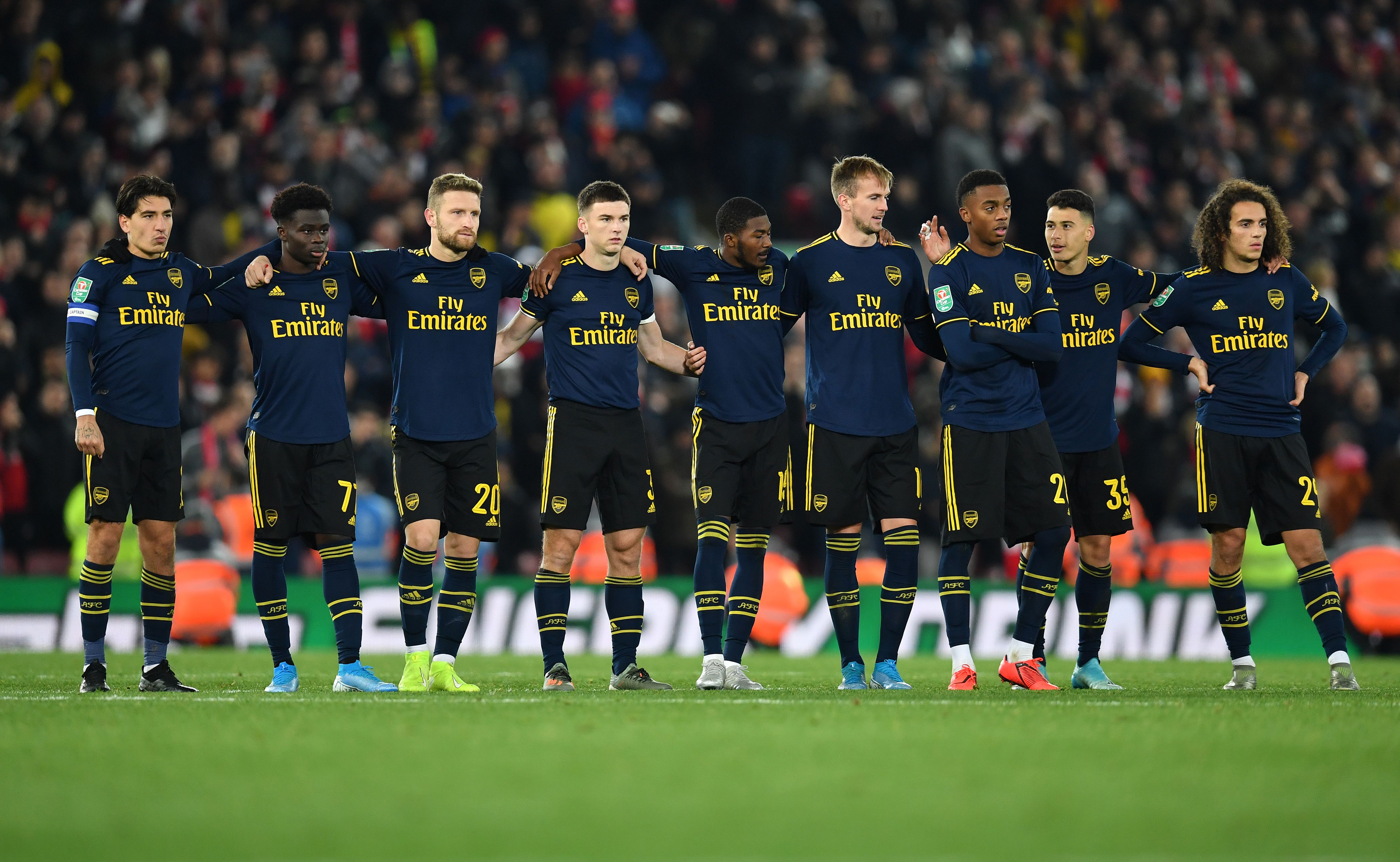 Arsenal's Spanish defender Hector Bellerin (L) stands with teammates as they wait to take their penalties in a penalty shoot-out during the English League Cup fourth round football match between Liverpool and Arsenal at Anfield in Liverpool, north west England on October 30, 2019. - Liverpool won the match after winning the penalty shoot out, following a 5-5 draw in the match. (Photo by Paul ELLIS / AFP) / RESTRICTED TO EDITORIAL USE. No use with unauthorized audio, video, data, fixture lists, club/league logos or 'live' services. Online in-match use limited to 75 images, no video emulation. No use in betting, games or single club/league/player publications. / (Photo by PAUL ELLIS/AFP via Getty Images)