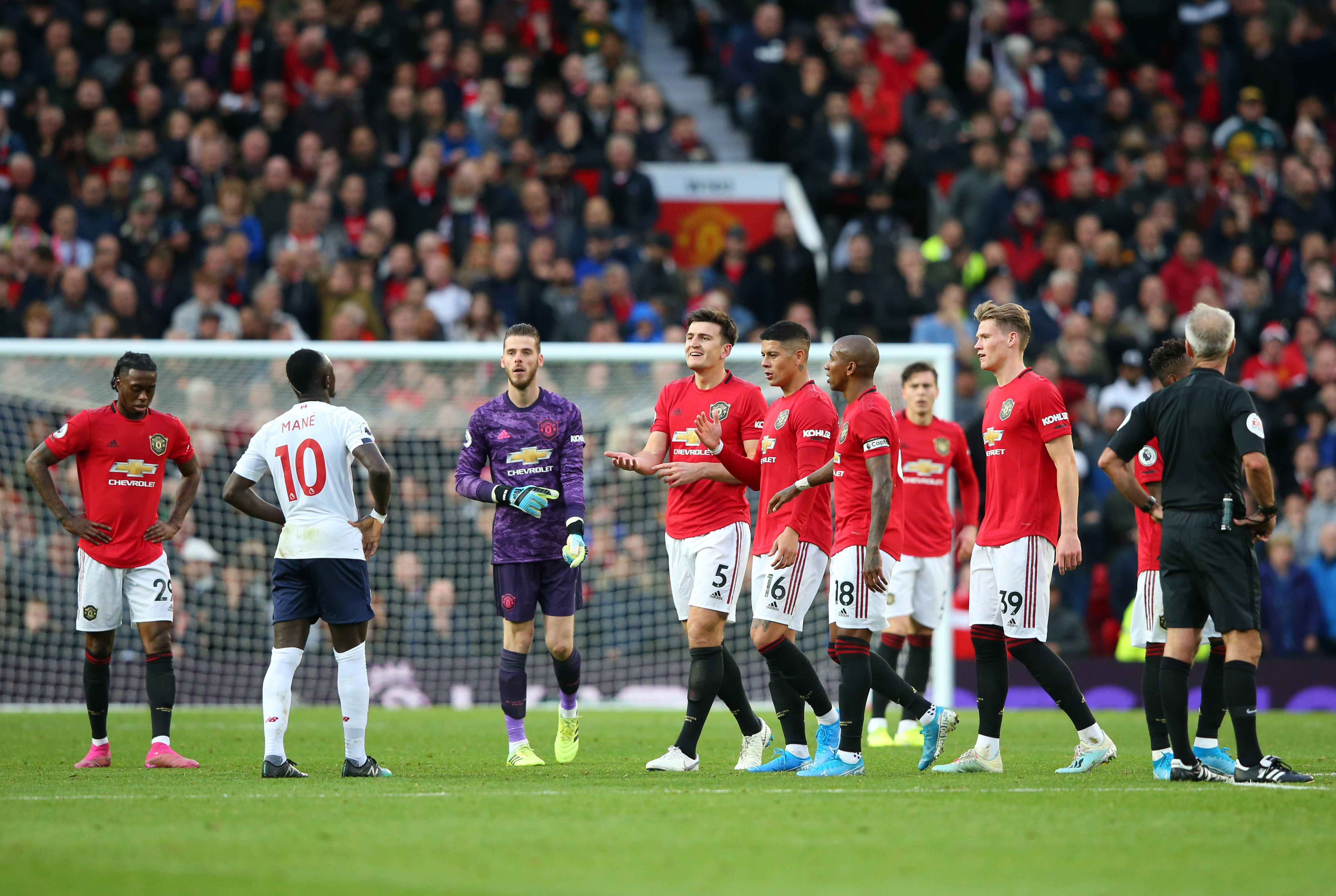 MANCHESTER, ENGLAND - OCTOBER 20: The Manchester United side approach Sadio Mané of Liverpool as his goal is disallowed during the Premier League match between Manchester United and Liverpool FC at Old Trafford on October 20, 2019 in Manchester, United Kingdom. (Photo by Alex Livesey/Getty Images)