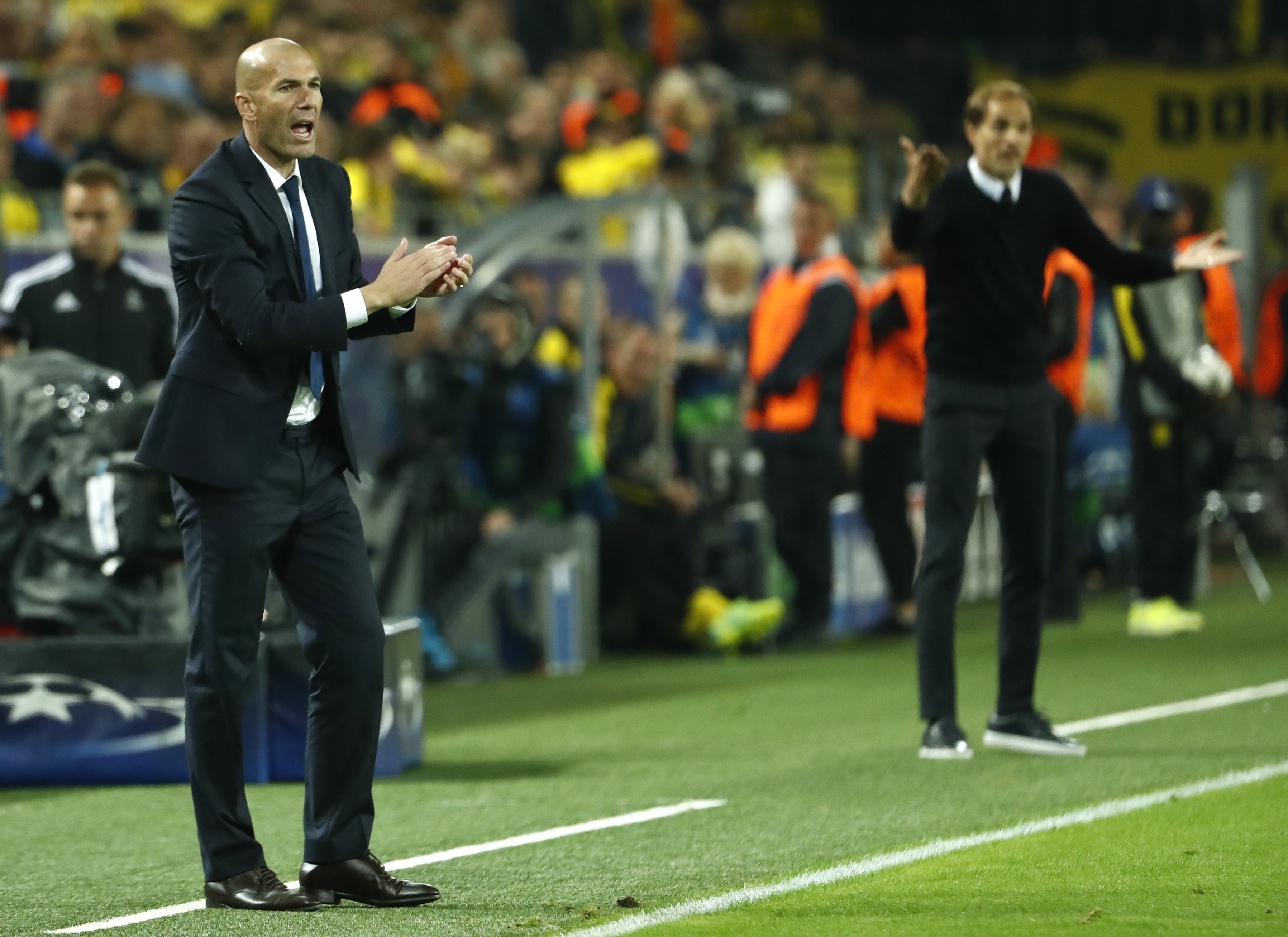 Real Madrid's French coach Zinedine Zidane (C) and Dortmund's head coach Thomas Tuchel (R) react during the UEFA Champions League first leg football match between Borussia Dortmund and Real Madrid at BVB stadium in Dortmund, on September 27, 2016. / AFP / Odd ANDERSEN (Photo credit should read ODD ANDERSEN/AFP via Getty Images)