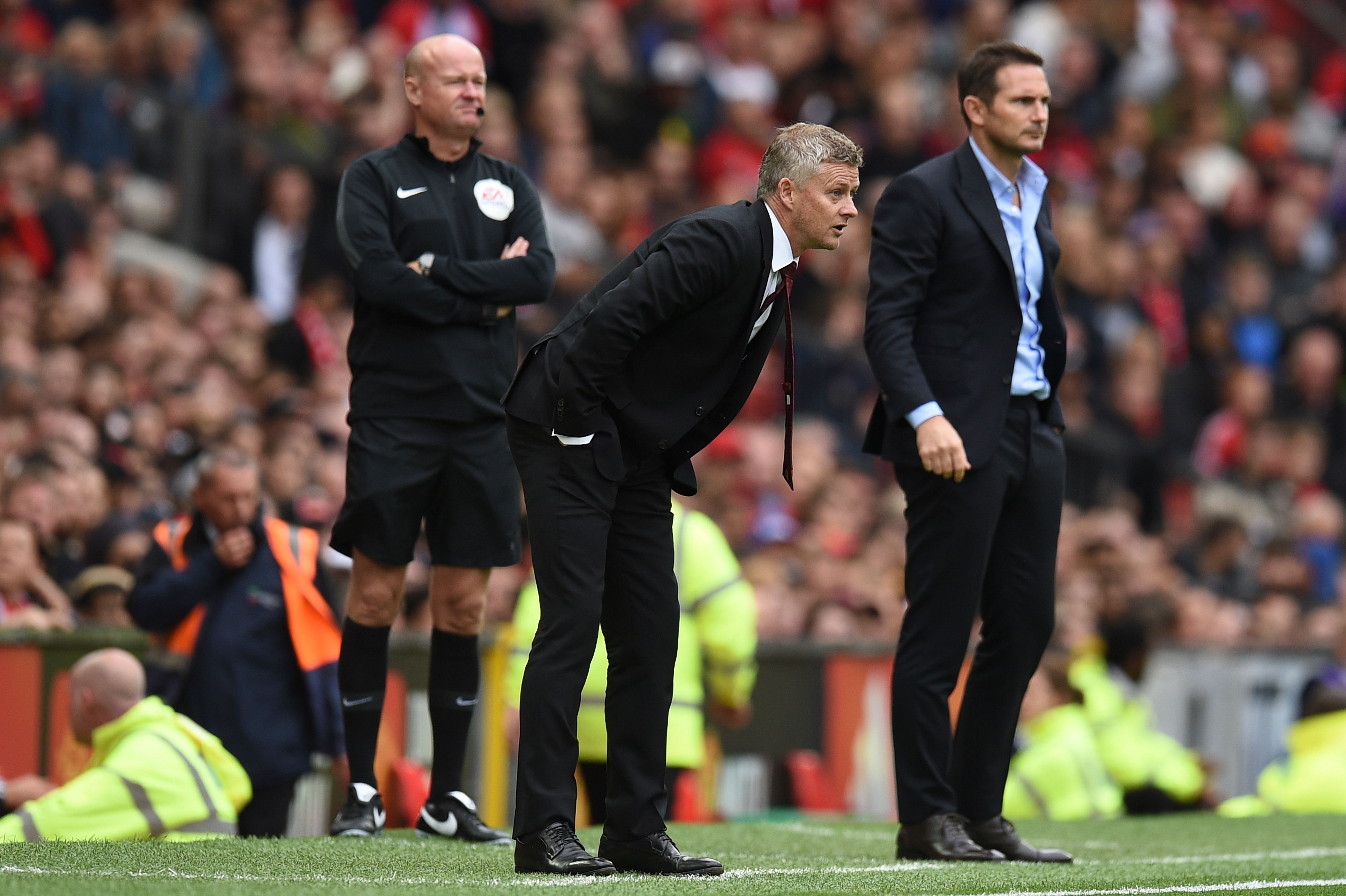 Manchester United's Norwegian manager Ole Gunnar Solskjaer (C) and Chelsea's English head coach Frank Lampard (R) look on during the English Premier League football match between Manchester United and Chelsea at Old Trafford in Manchester, north west England, on August 11, 2019. (Photo by Oli SCARFF / AFP) / RESTRICTED TO EDITORIAL USE. No use with unauthorized audio, video, data, fixture lists, club/league logos or 'live' services. Online in-match use limited to 120 images. An additional 40 images may be used in extra time. No video emulation. Social media in-match use limited to 120 images. An additional 40 images may be used in extra time. No use in betting publications, games or single club/league/player publications. / (Photo credit should read OLI SCARFF/AFP via Getty Images)